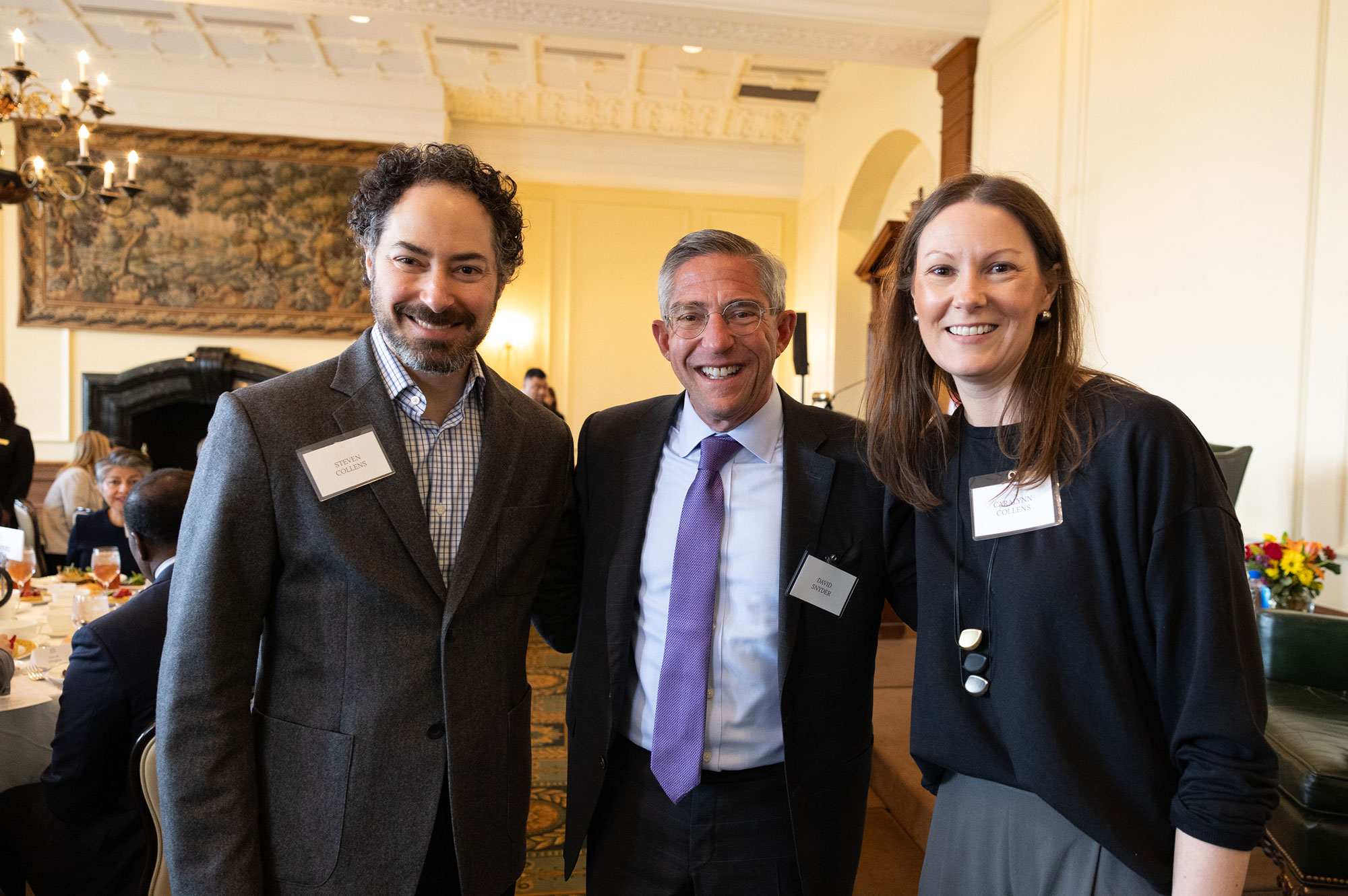 Three people standing and smiling