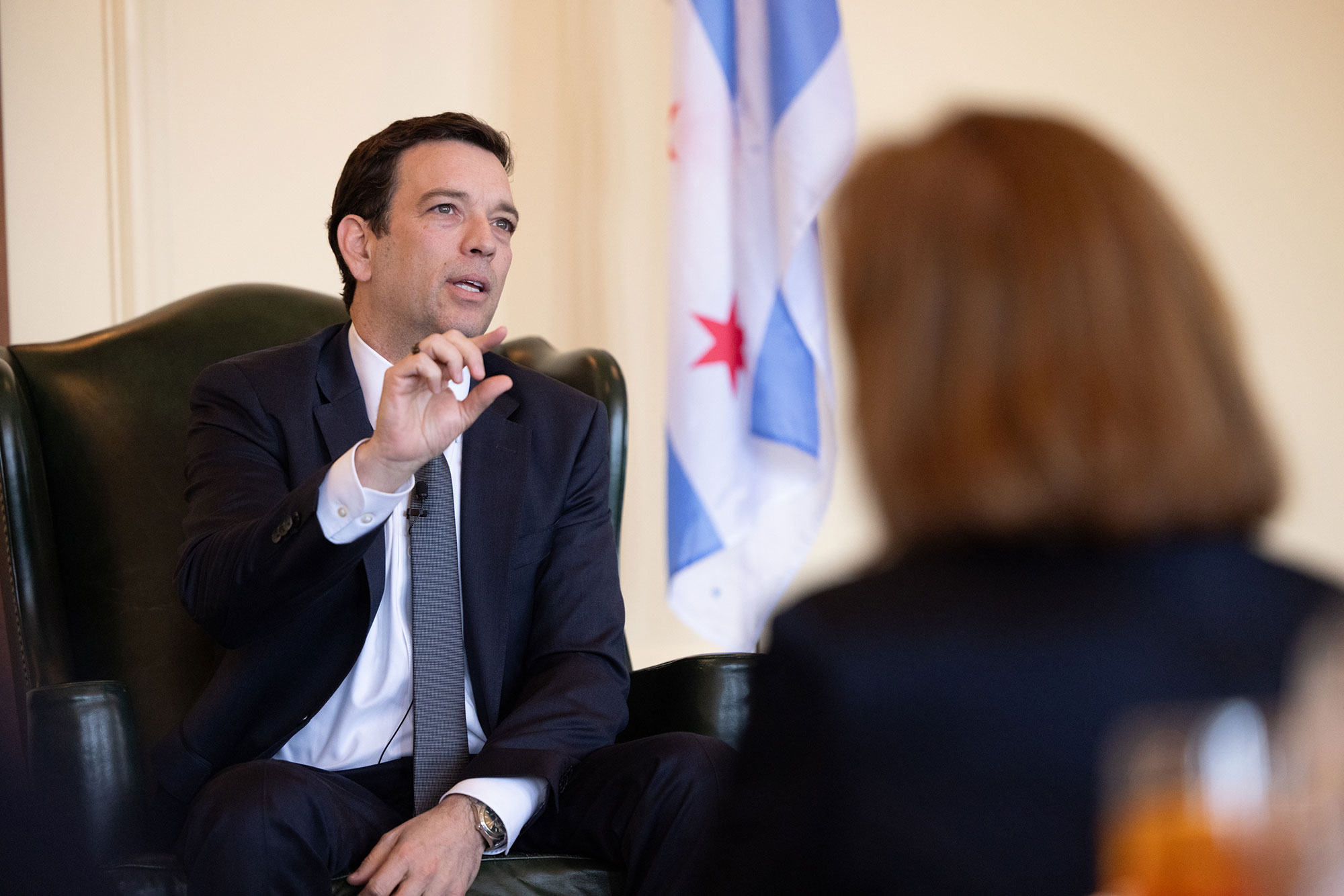 A person talking while sitting in a chair