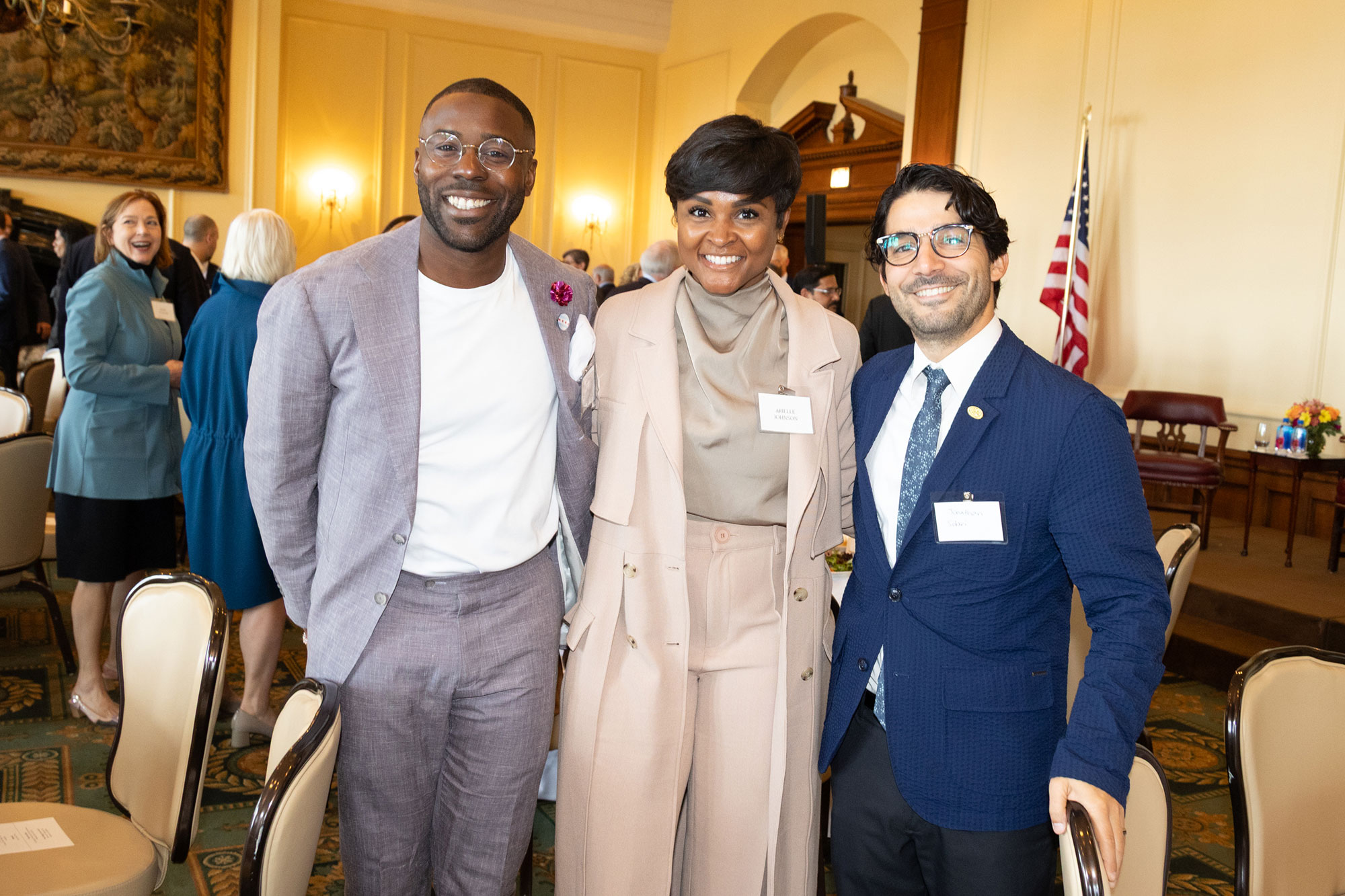 Three people stand together, facing the camera