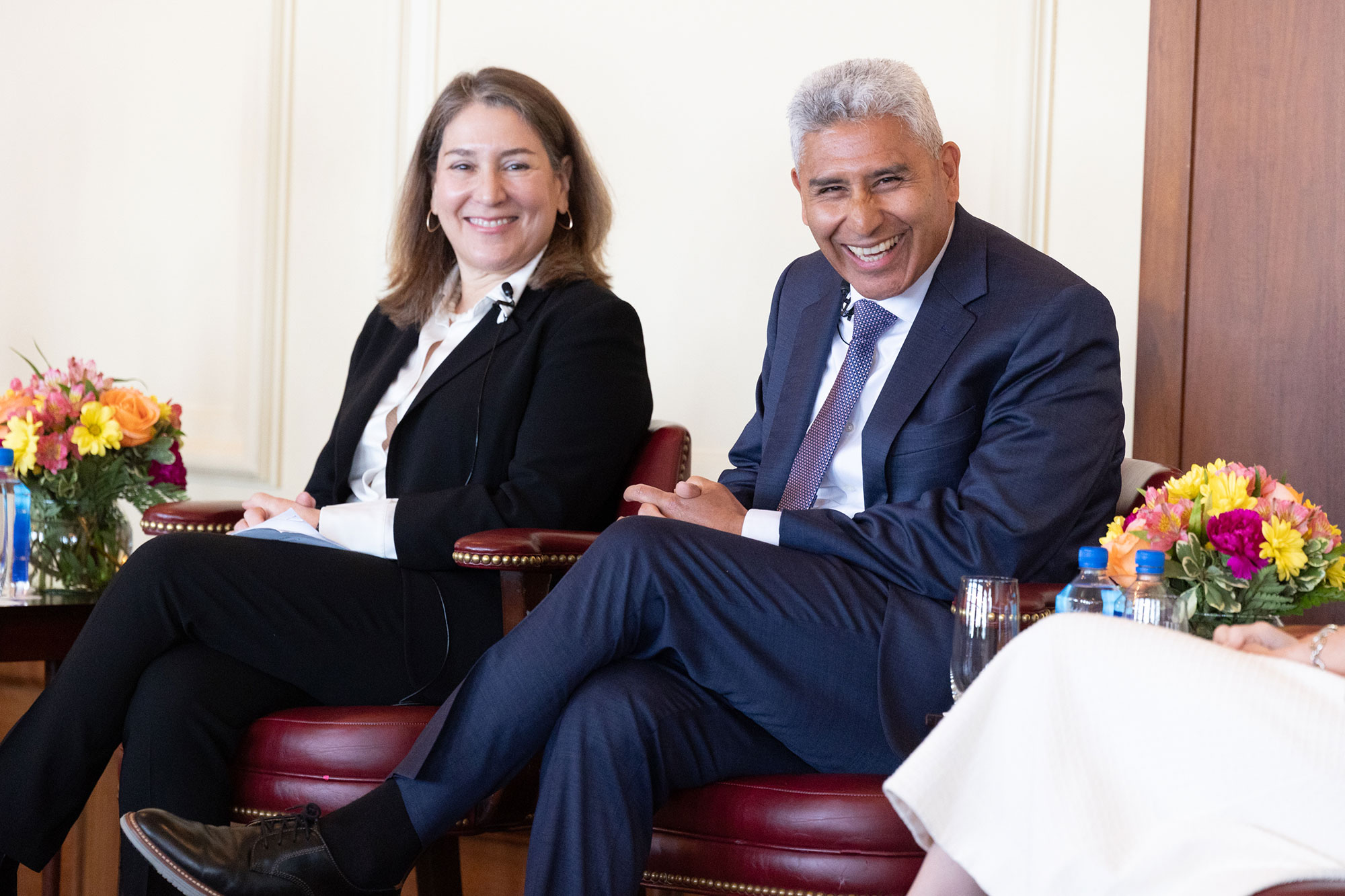 Two people sitting in chairs and smiling