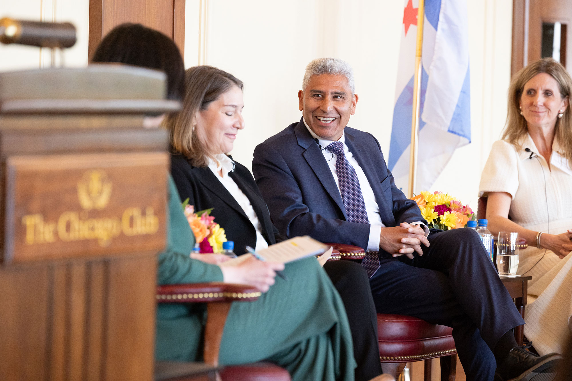 People engage in conversation while sitting on stage