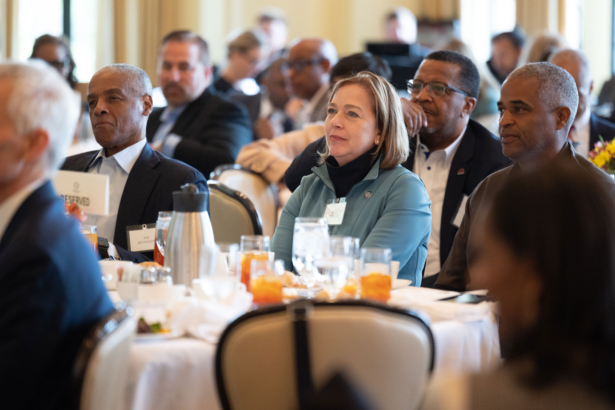 People sitting at a table listen in the audience