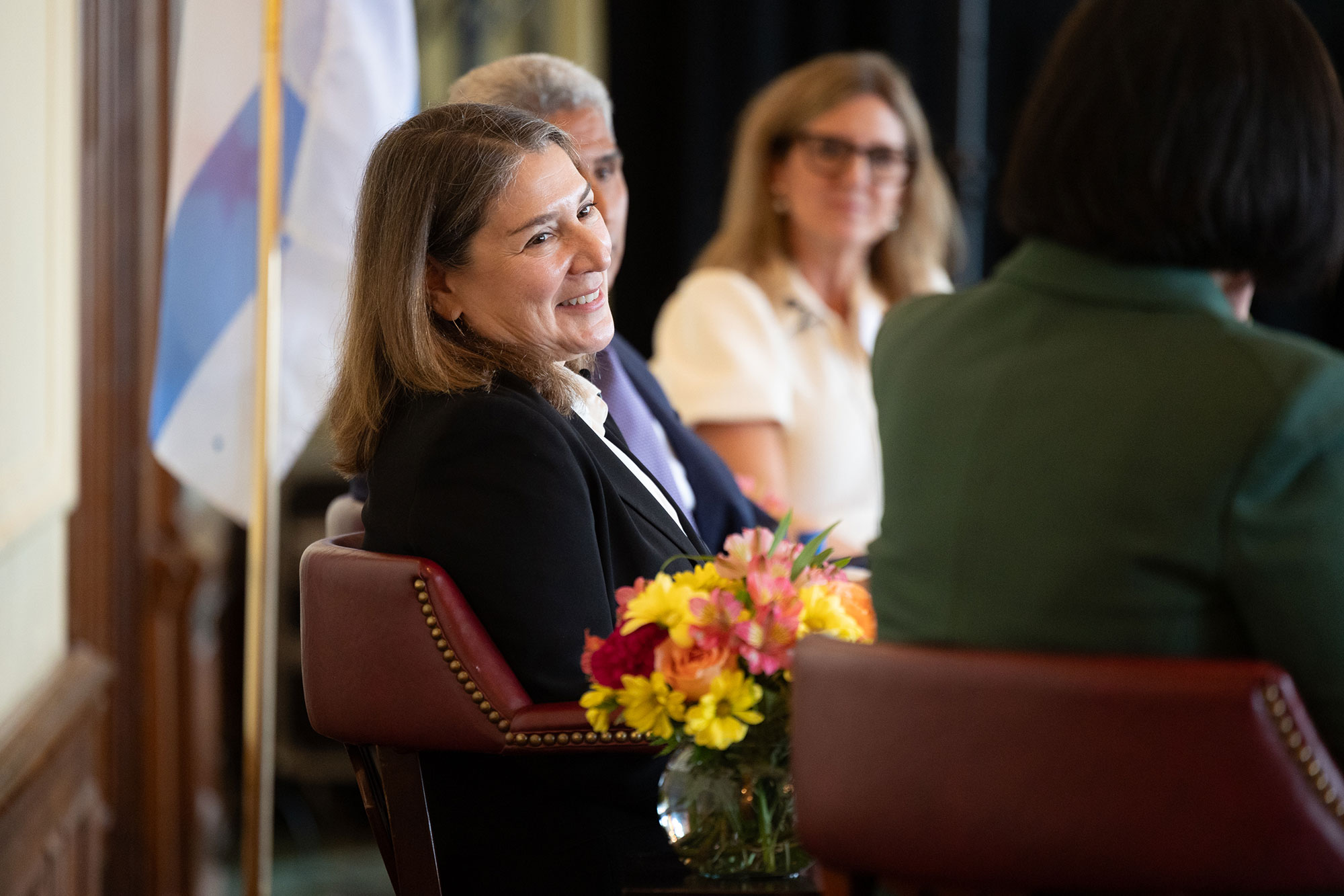 People talking while sitting in chairs on stage