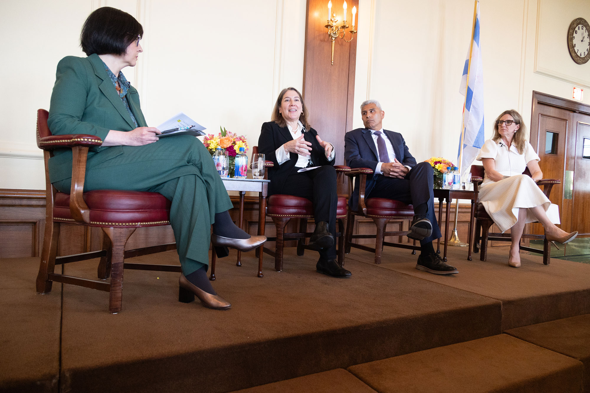 Four people talk while sitting on stage