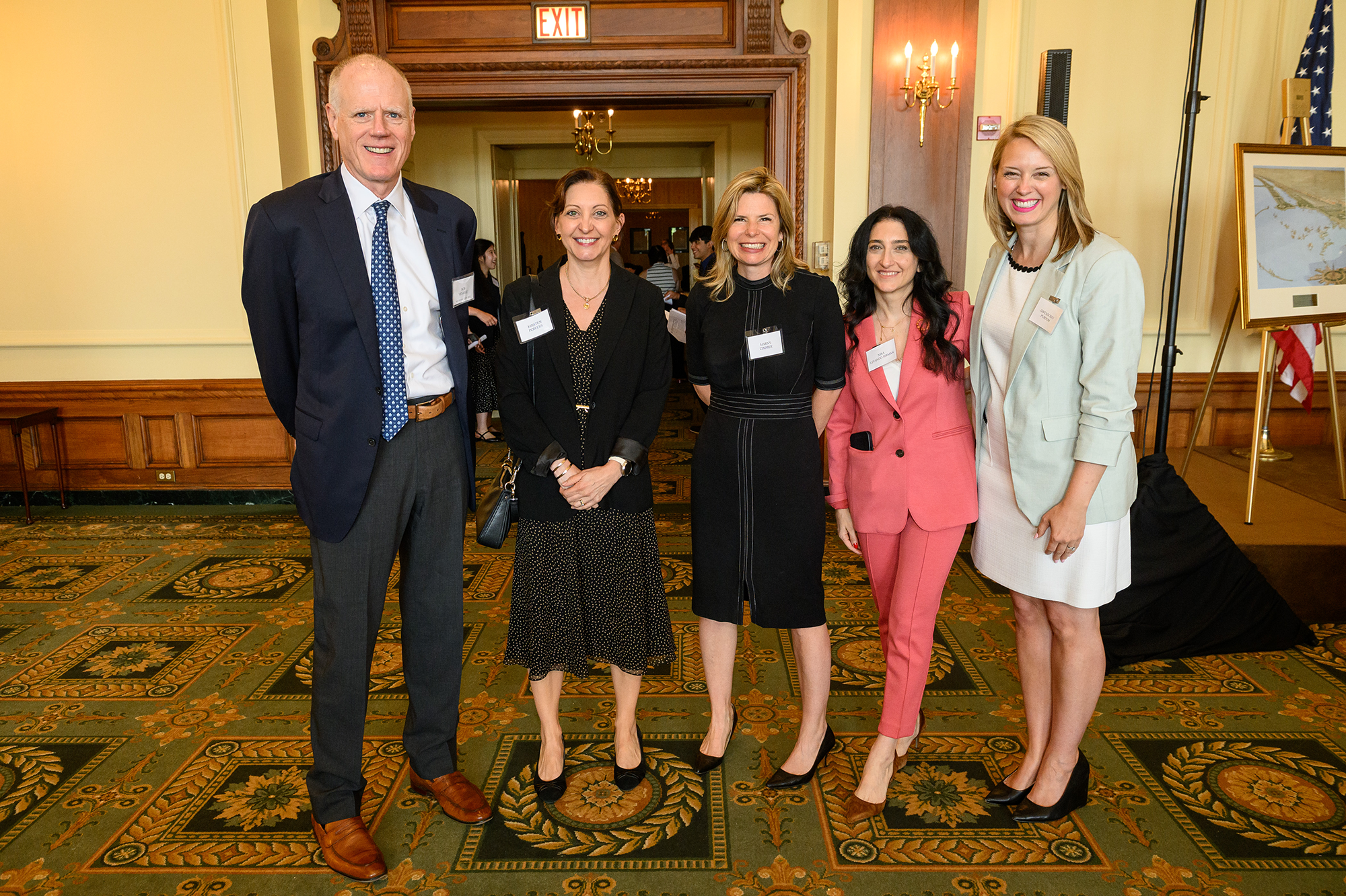 Five people standing and smiling