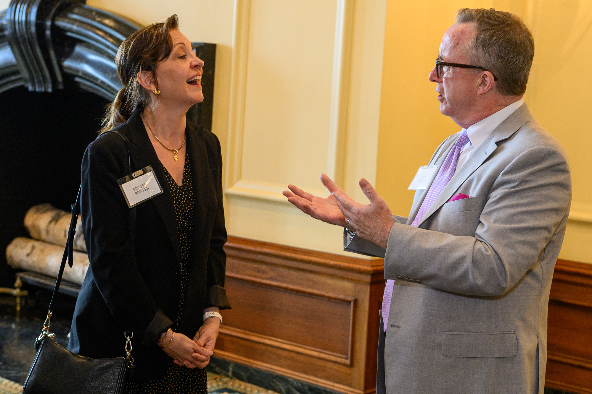 Two people talk and laugh while standing