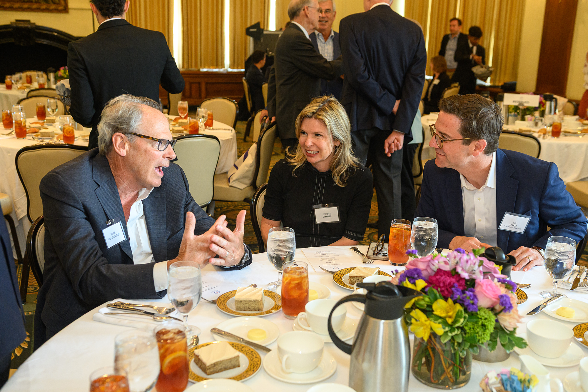 Three people talk while sitting at a table together