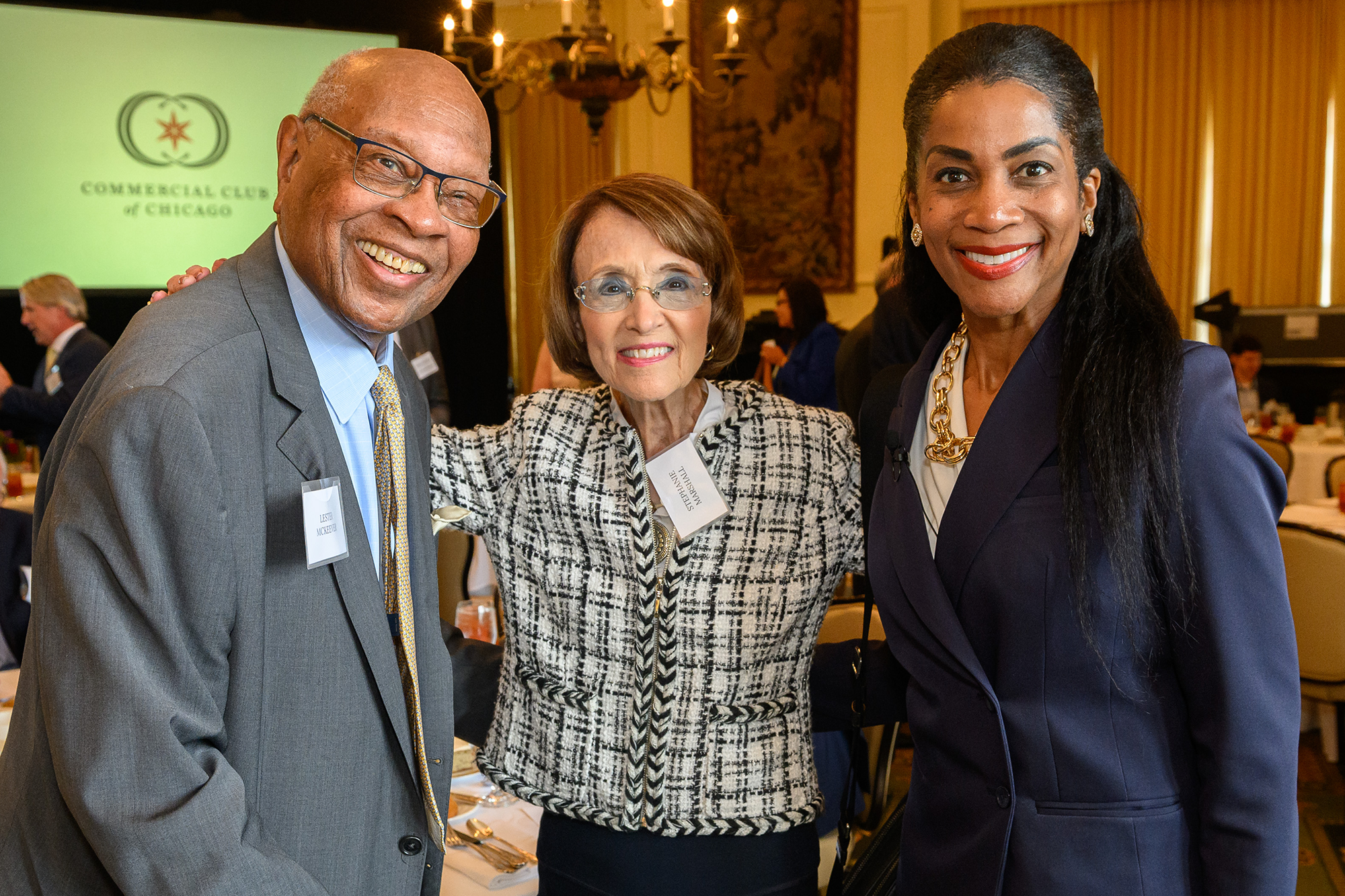 Three people stand together facing the camera