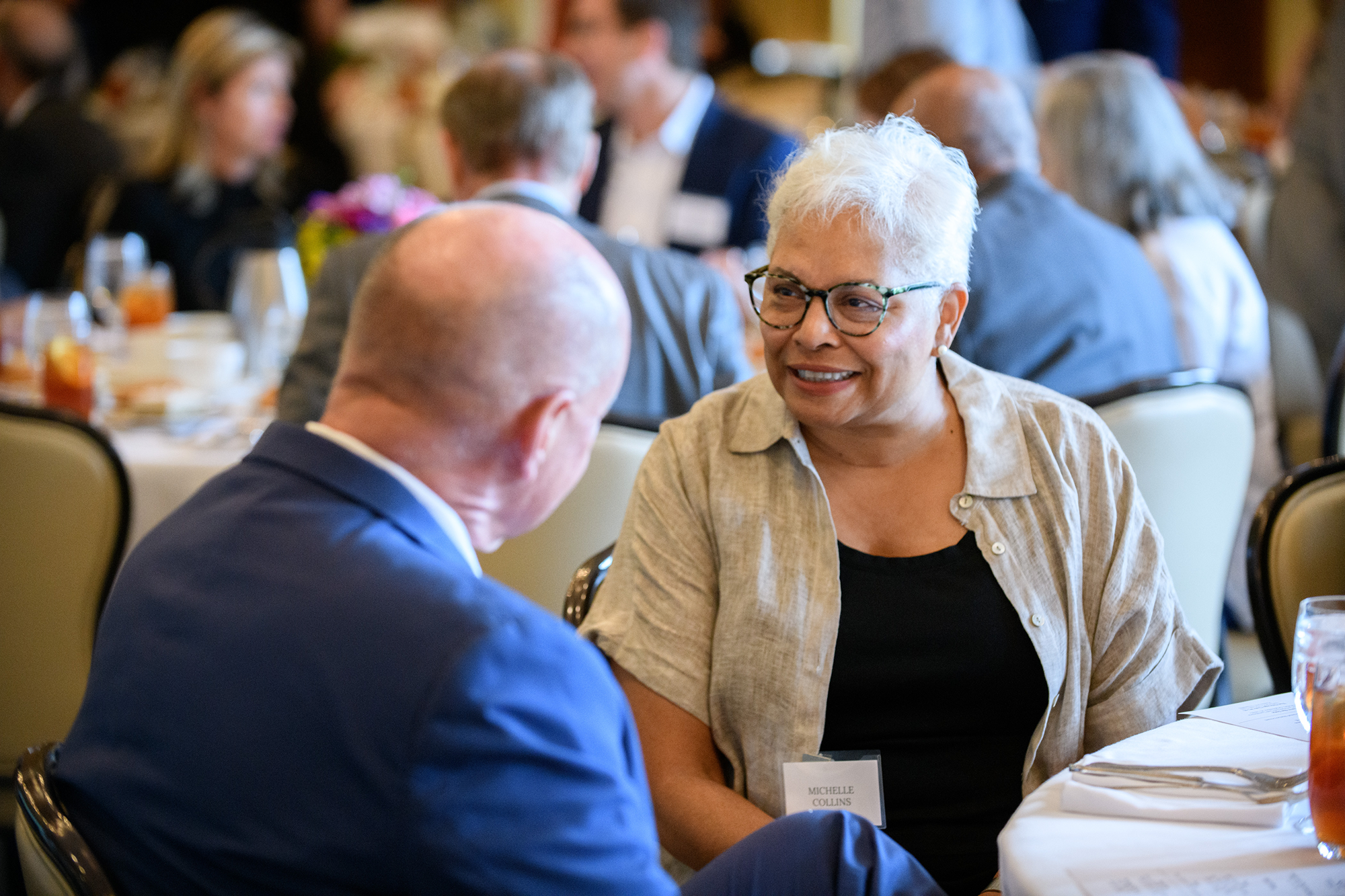 Two people talk while sitting at a table