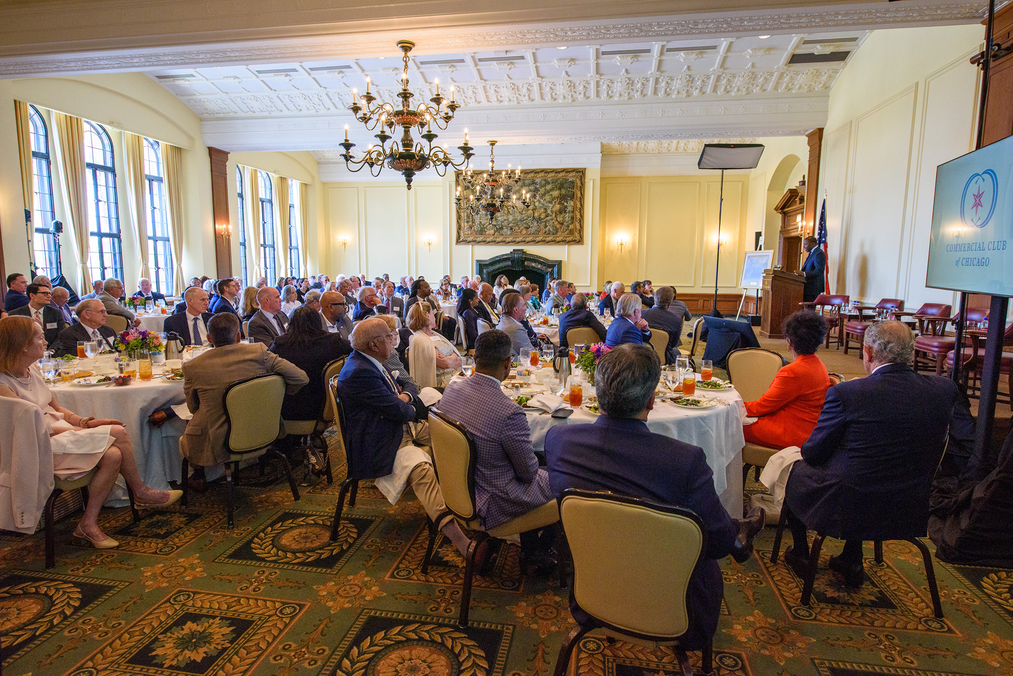 A ballroom of people sitting at dinner tables