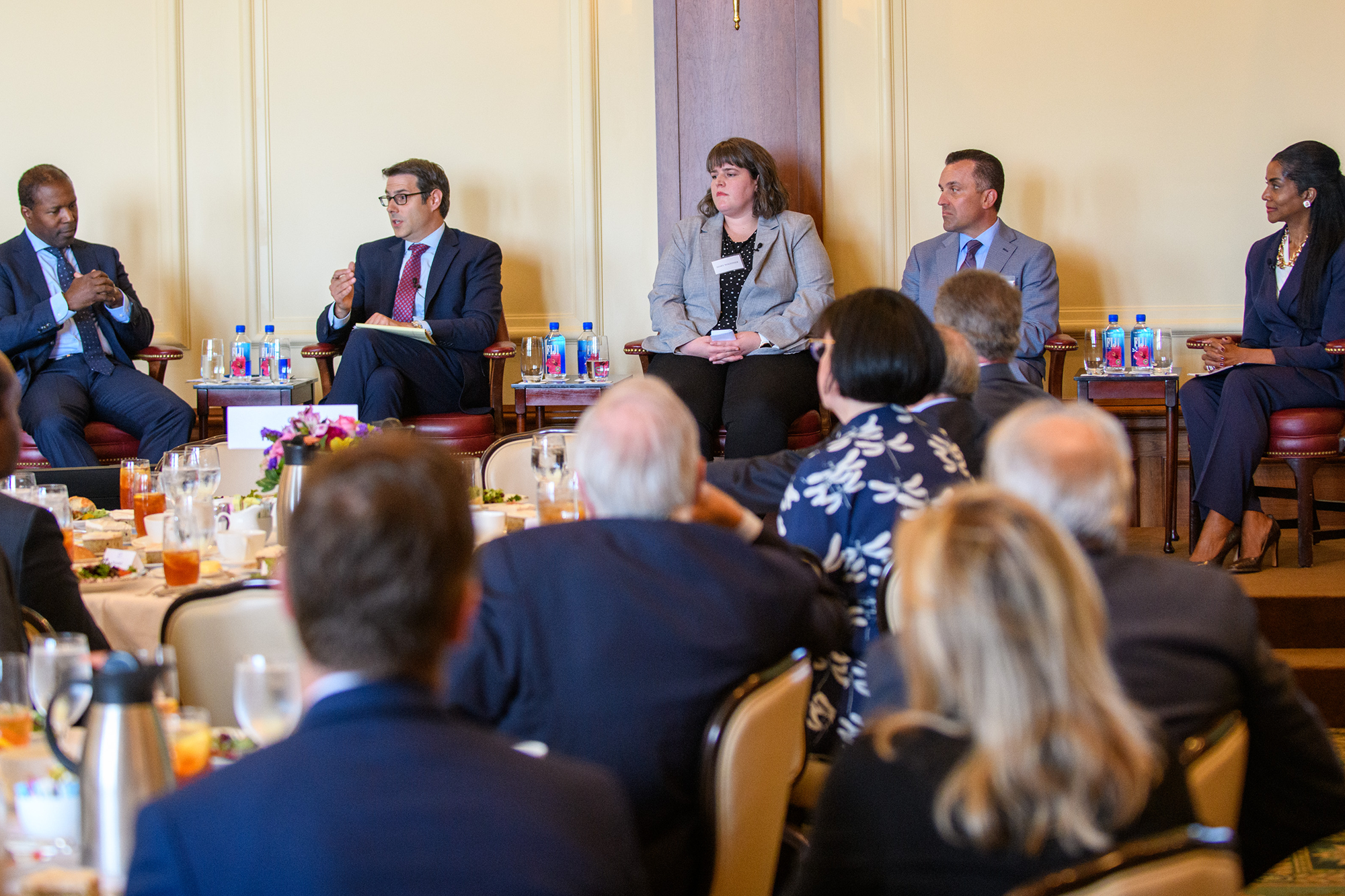 People engage in conversation while sitting on stage