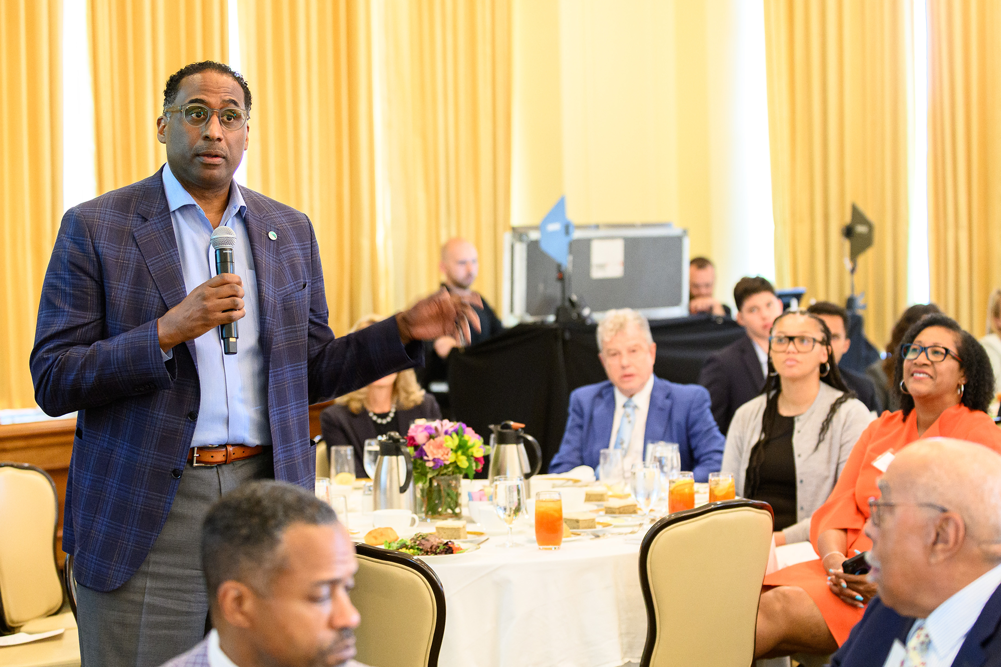 A person speaks into a microphone while standing