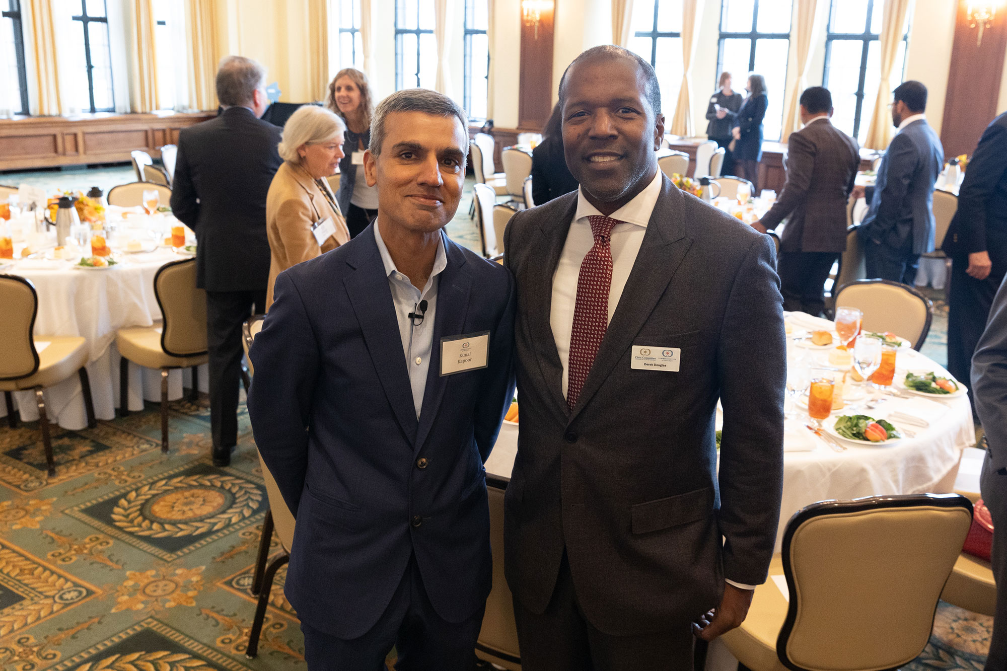 Two people stand together in front of dining tables