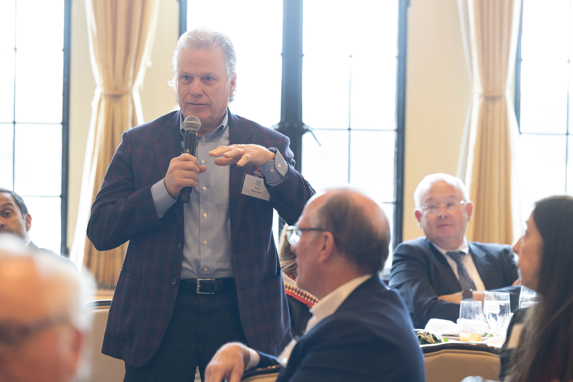 A person stands while talking into a microphone