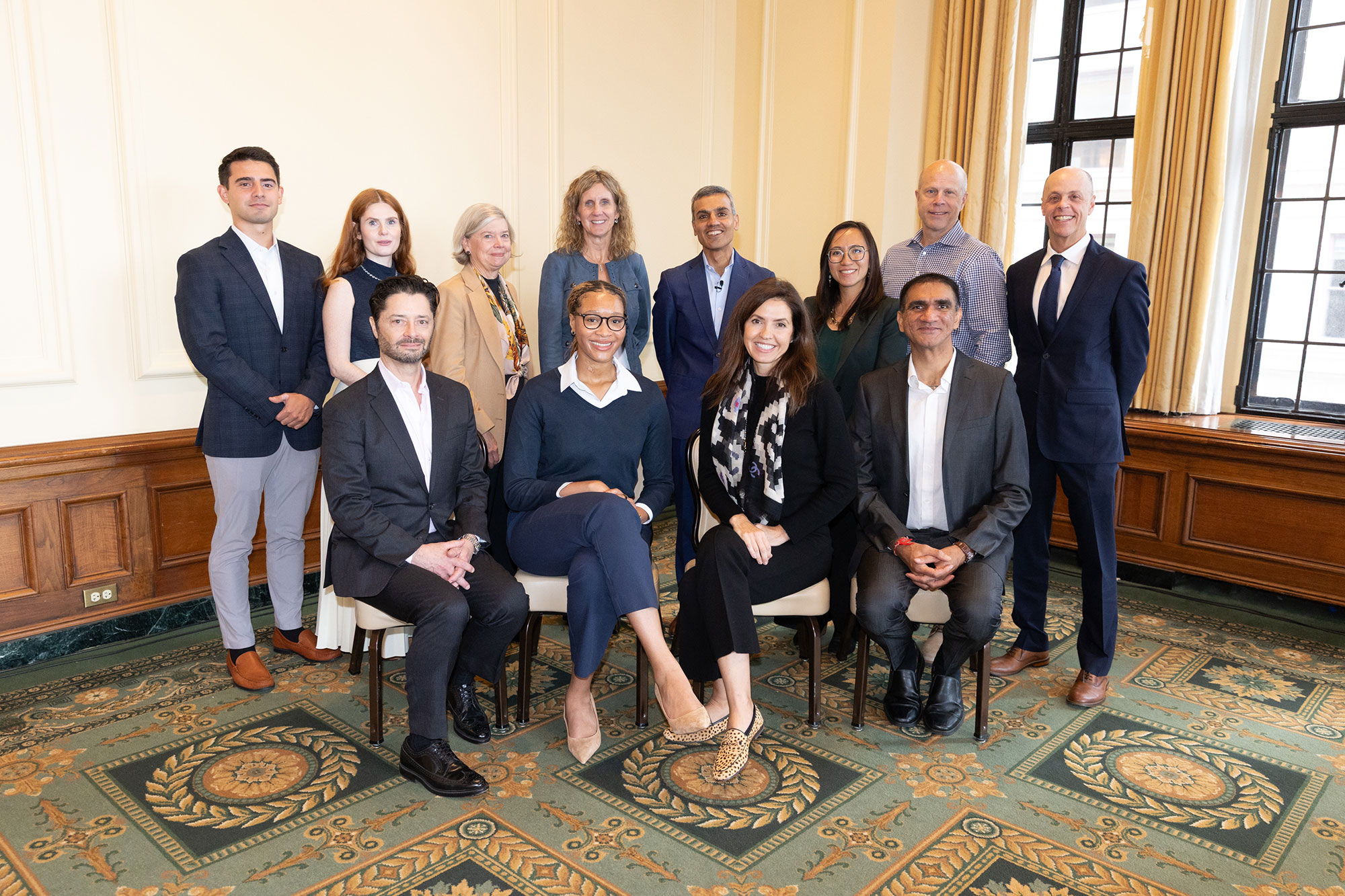 A group of people pose, some sitting in chairs