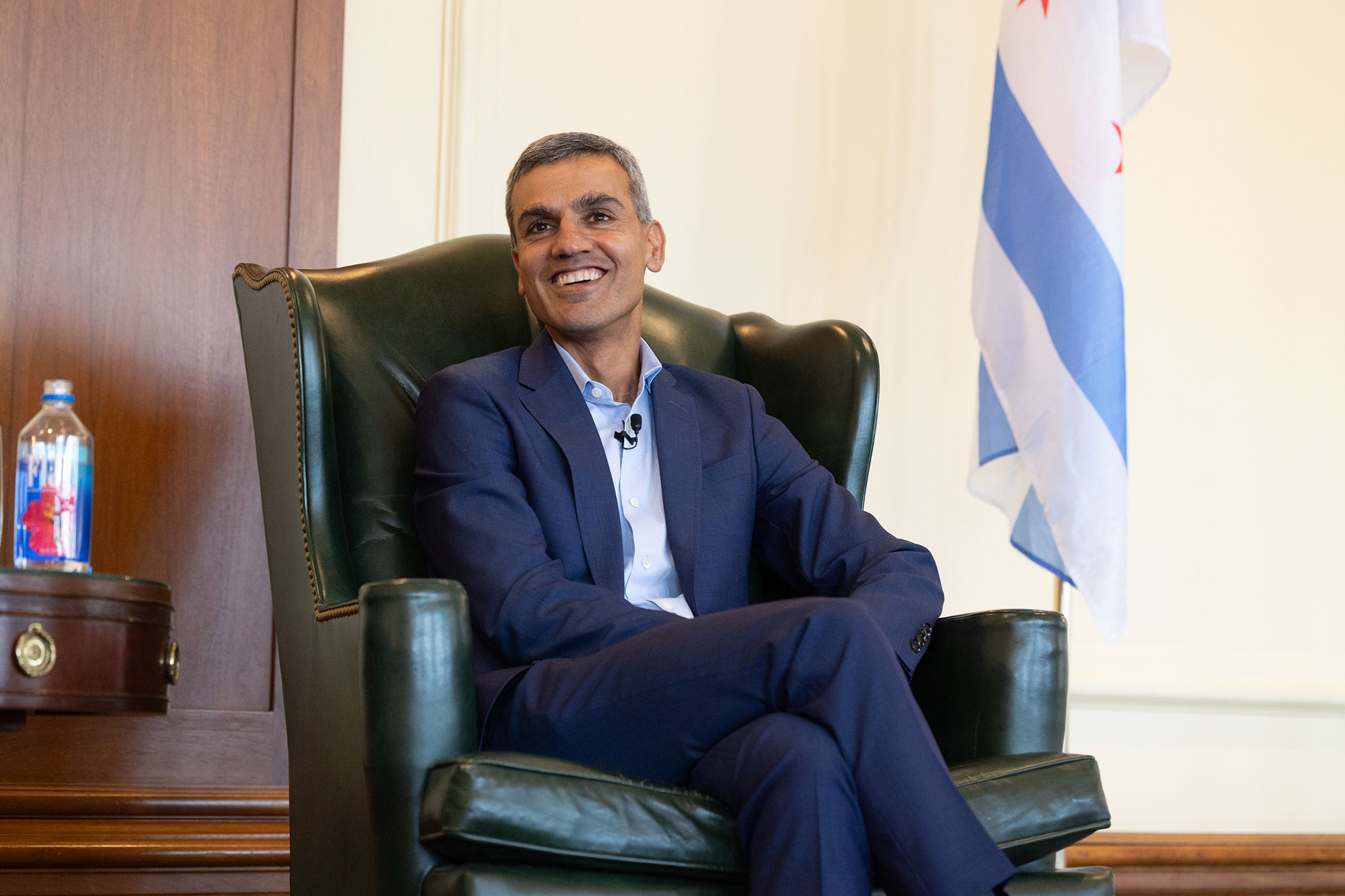 A person sitting in a chair on-stage while smiling