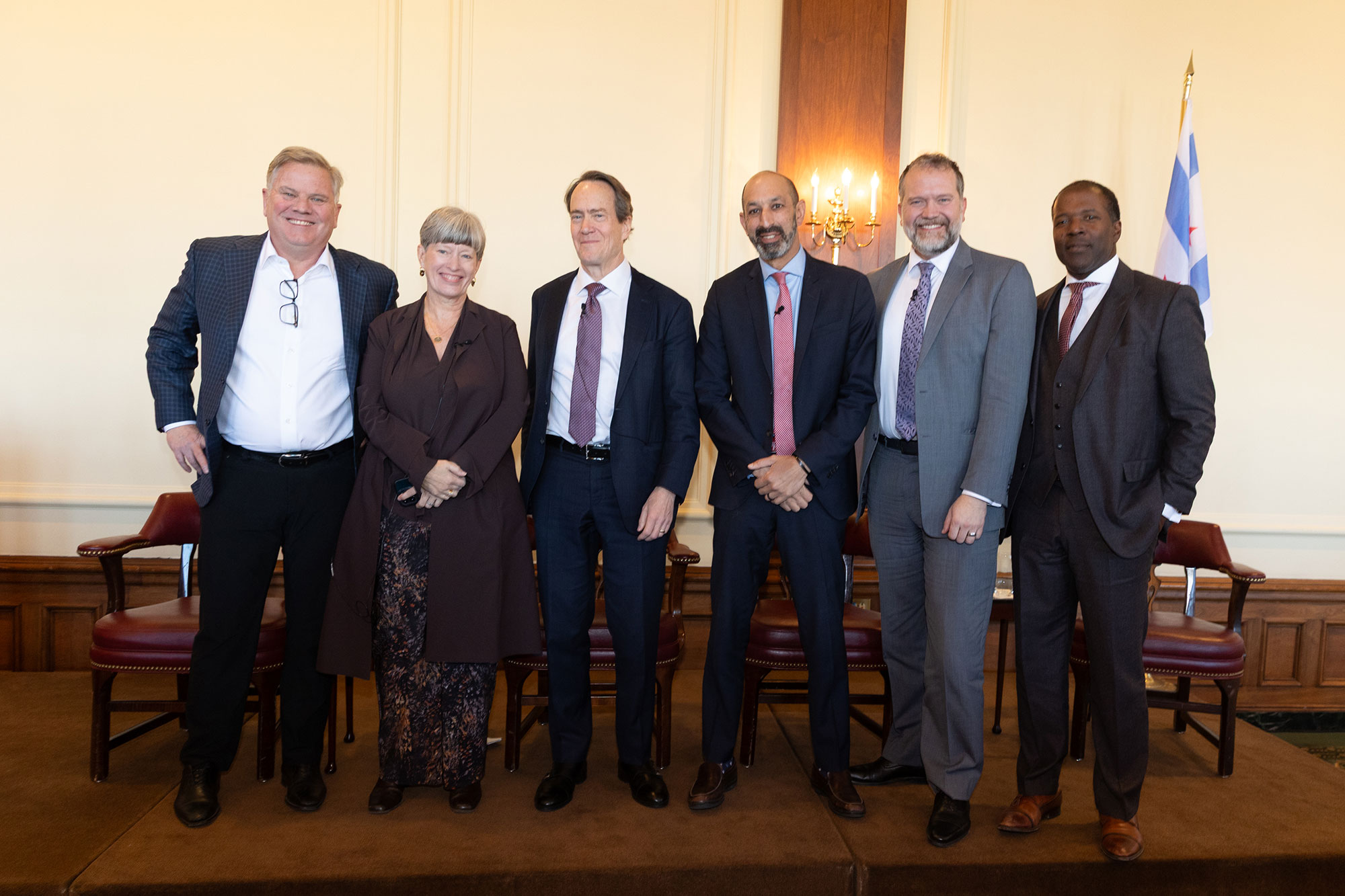 6 people stand on stage and pose