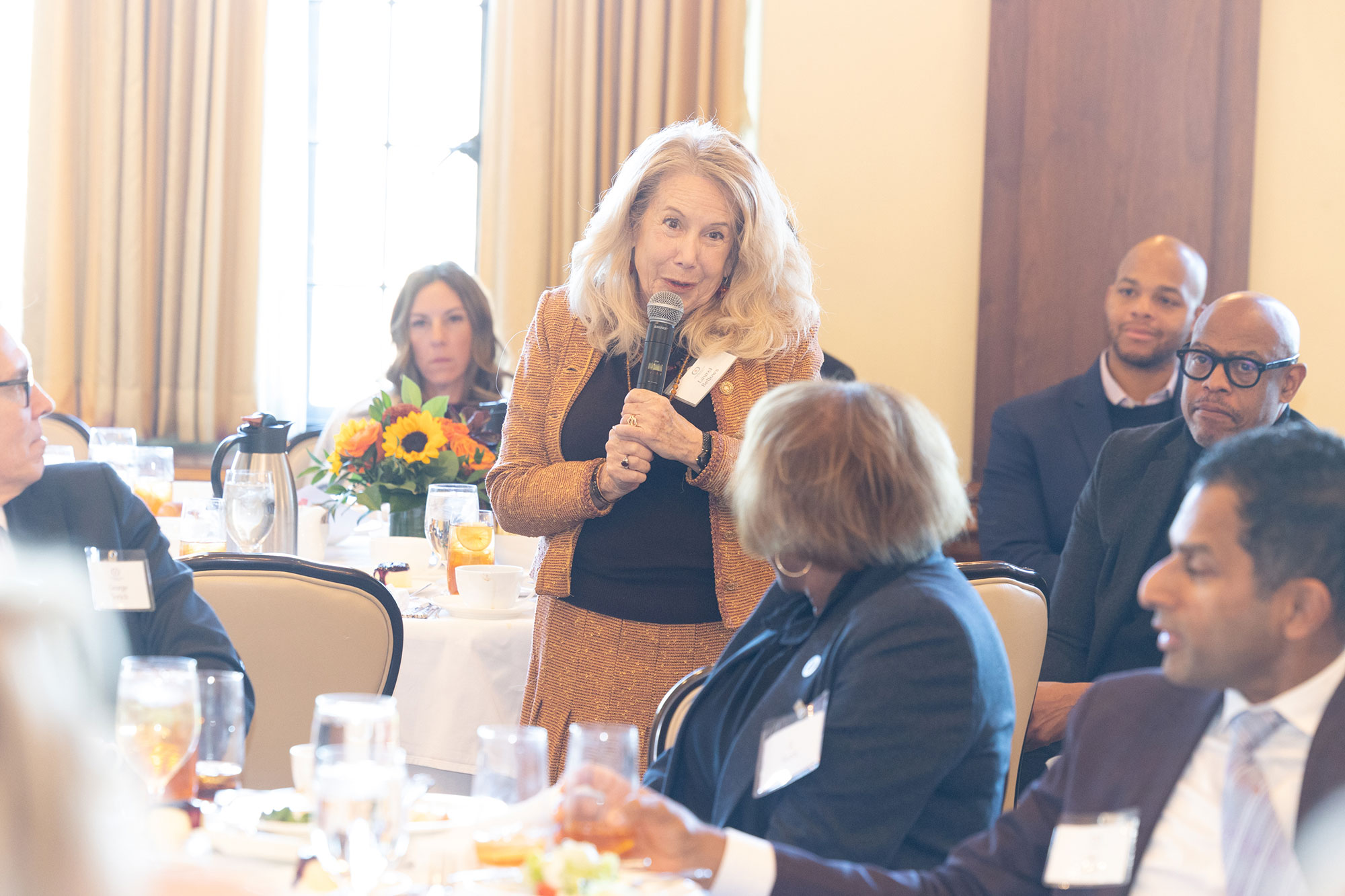 A person stands and talks into a microphone