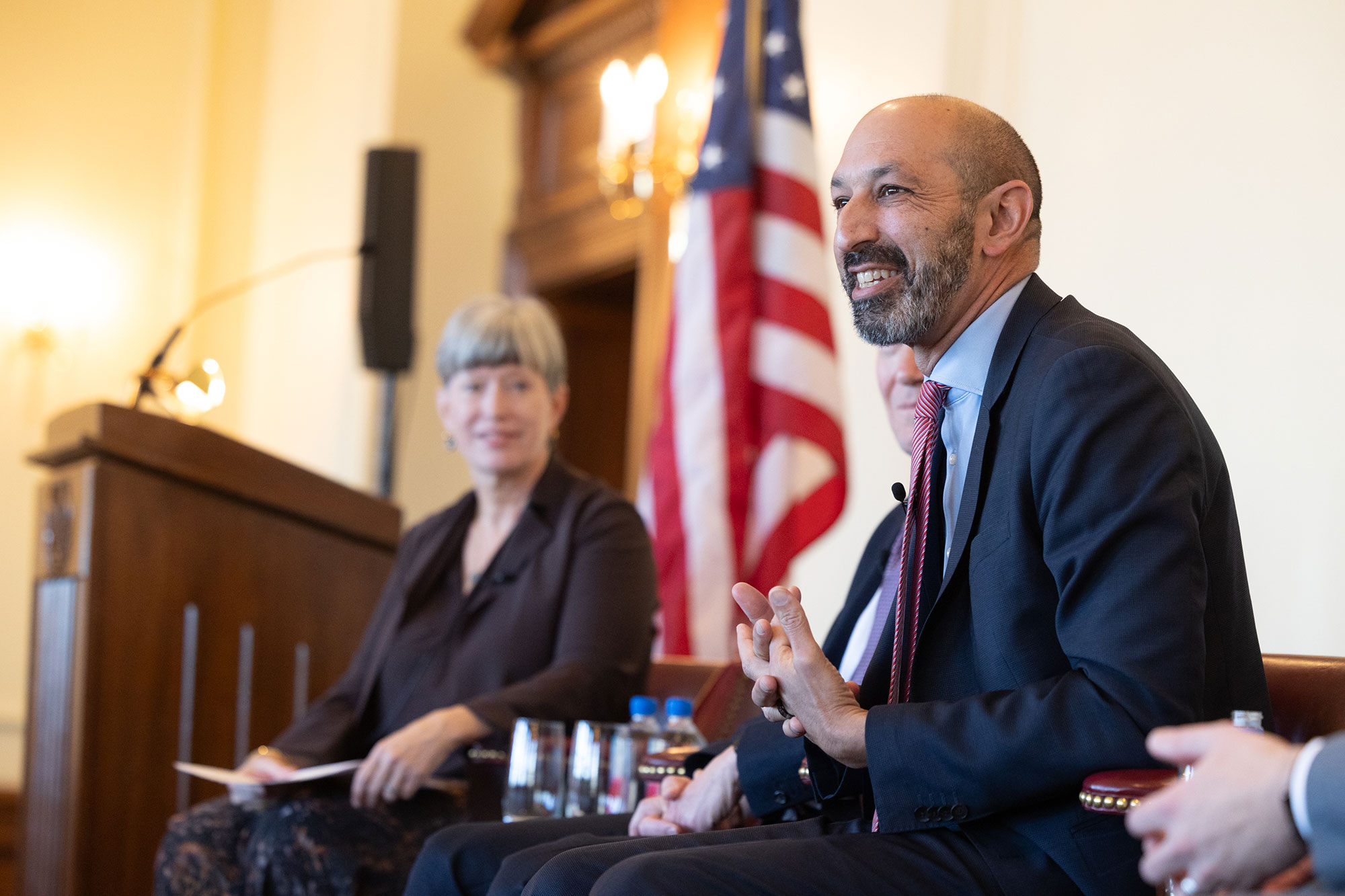 A person sits in a chair on stage while talking