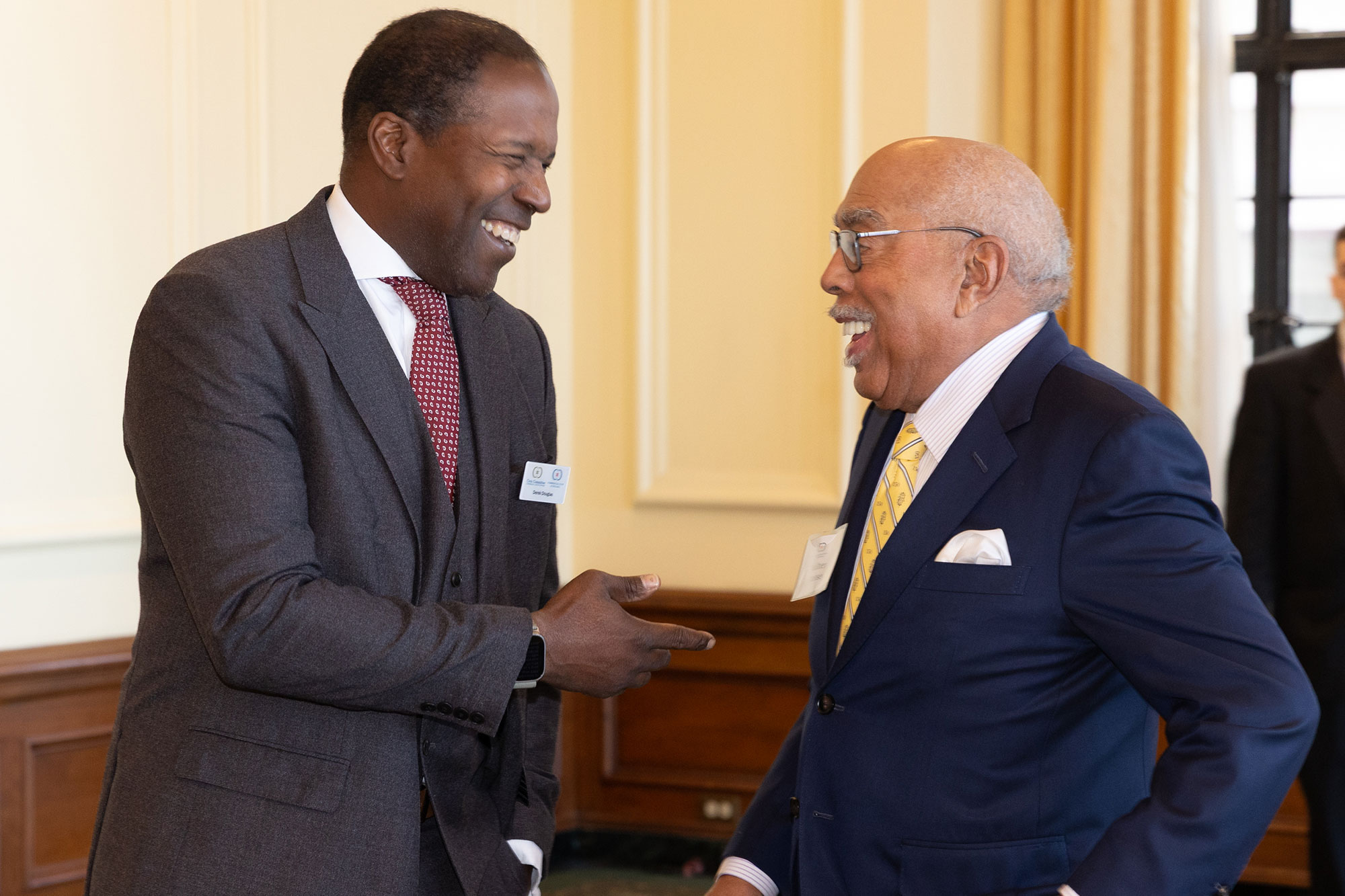 Two people stand together laughing