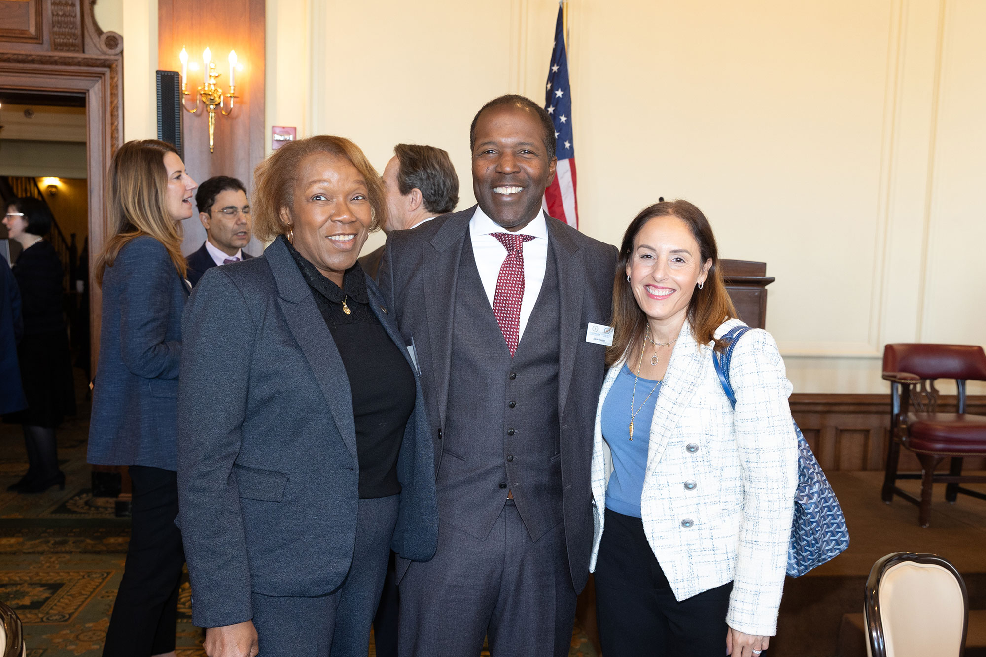 Three people stand and pose together