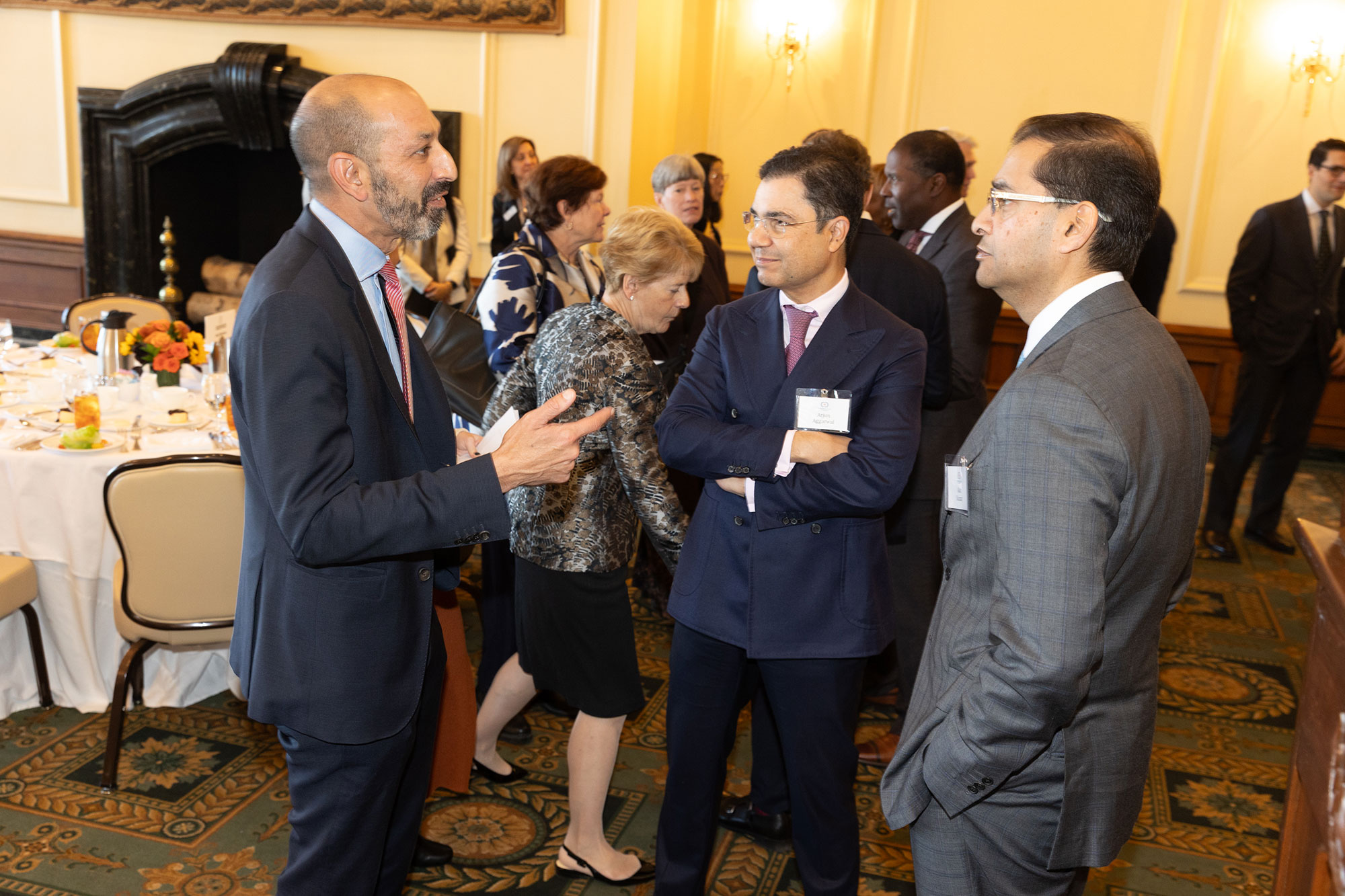Three people stand together talking