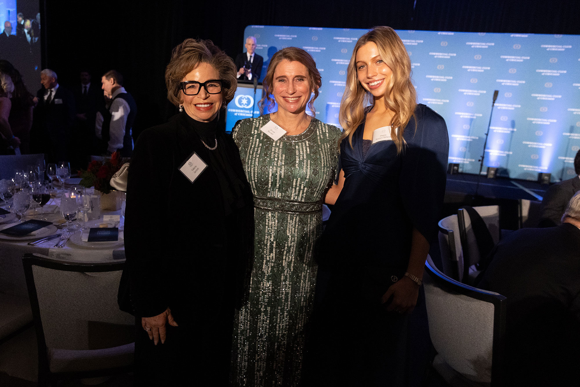 Three people stand and pose together