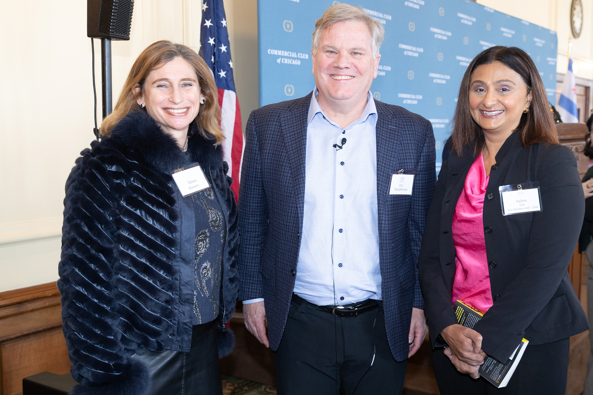 Three people stand together posing