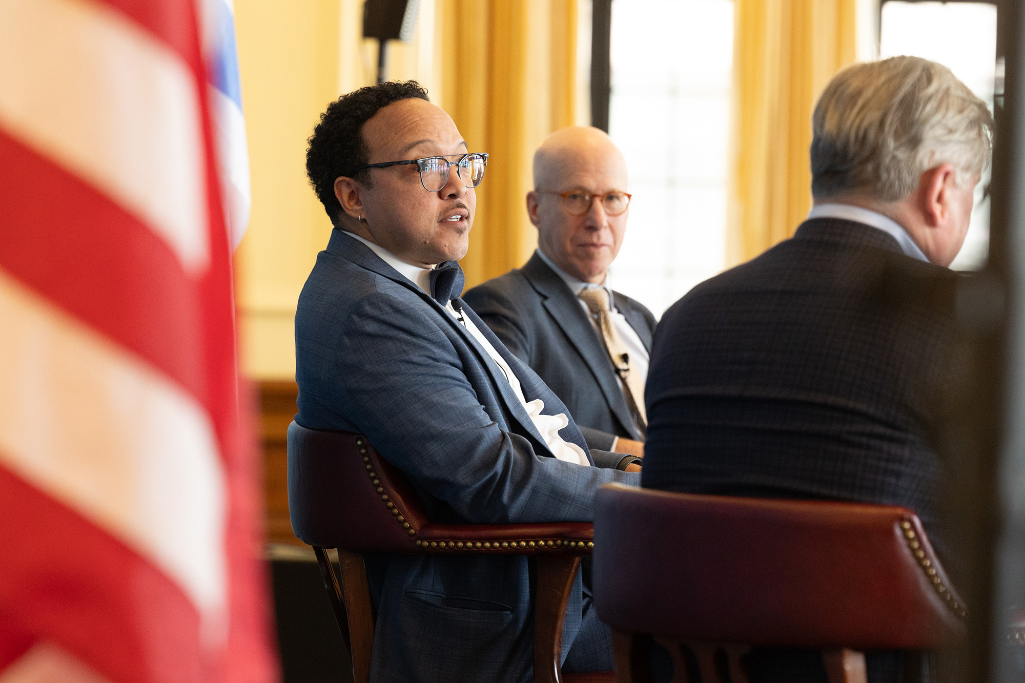 People sit in chairs while talking on stage