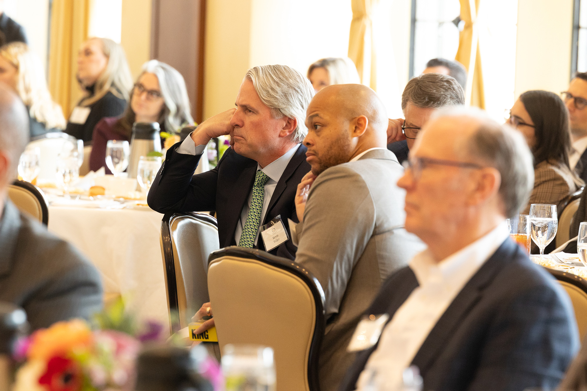 People sit at tables in the audience
