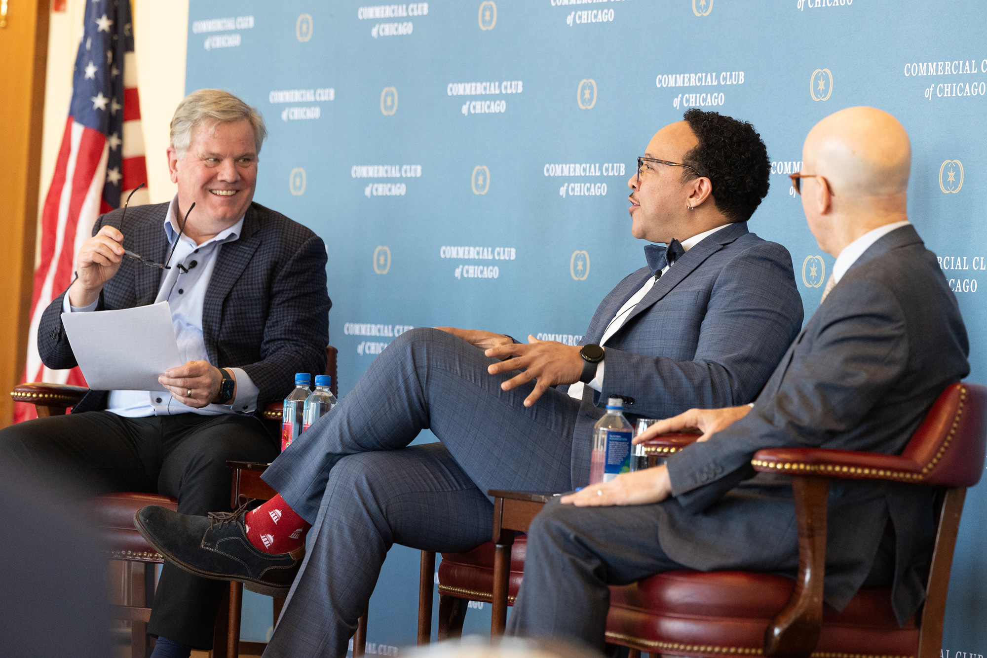 Three people laugh while talking