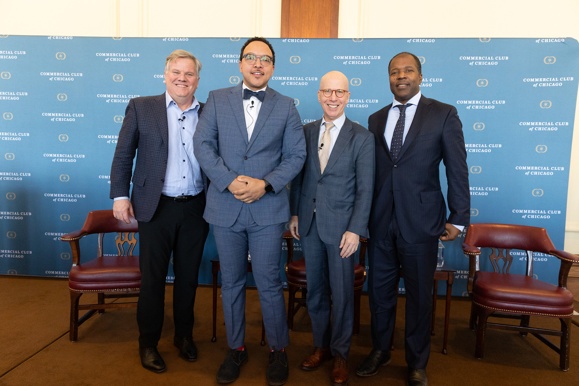 Four people stand together on stage