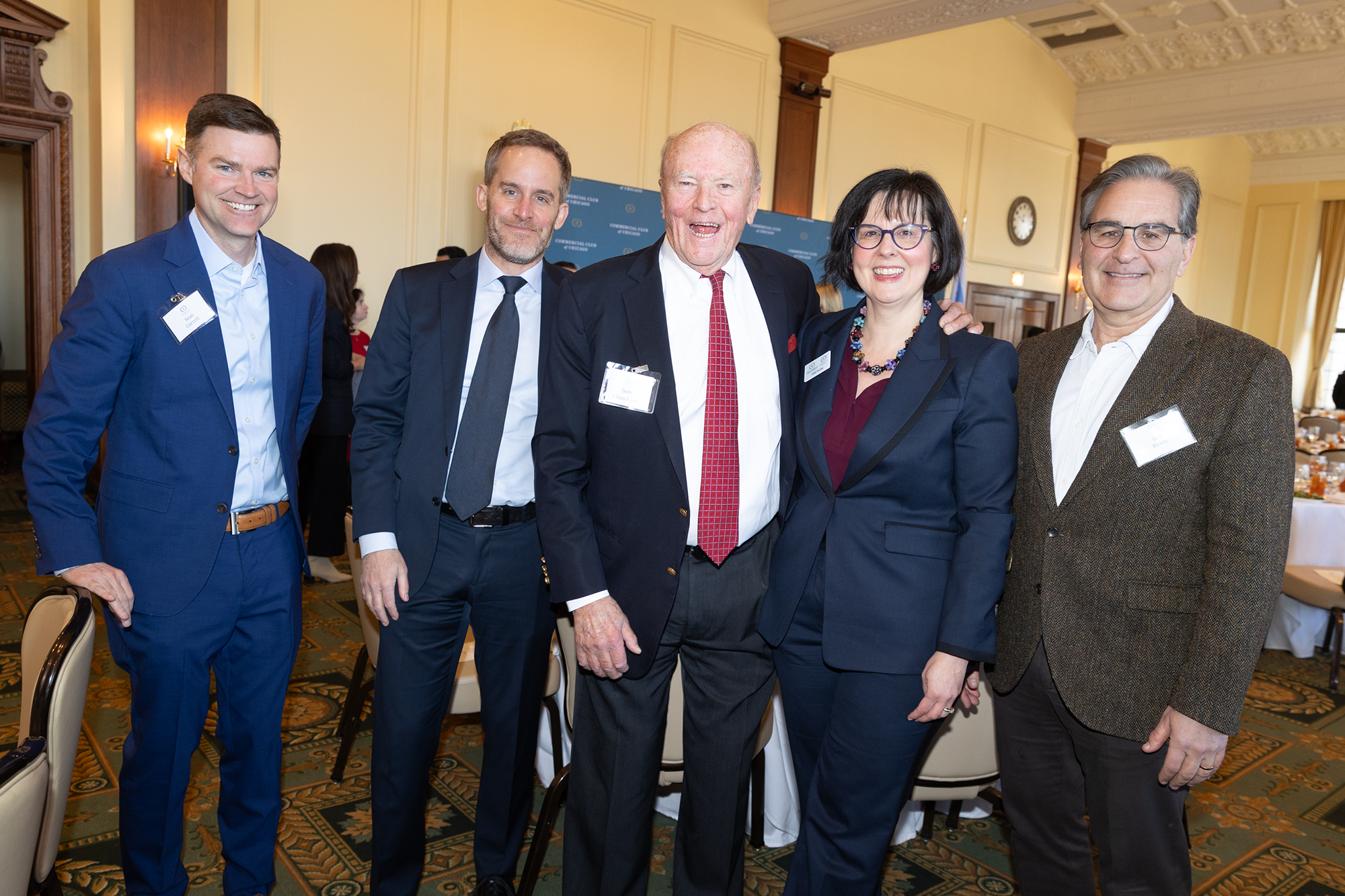 Five people stand together posing