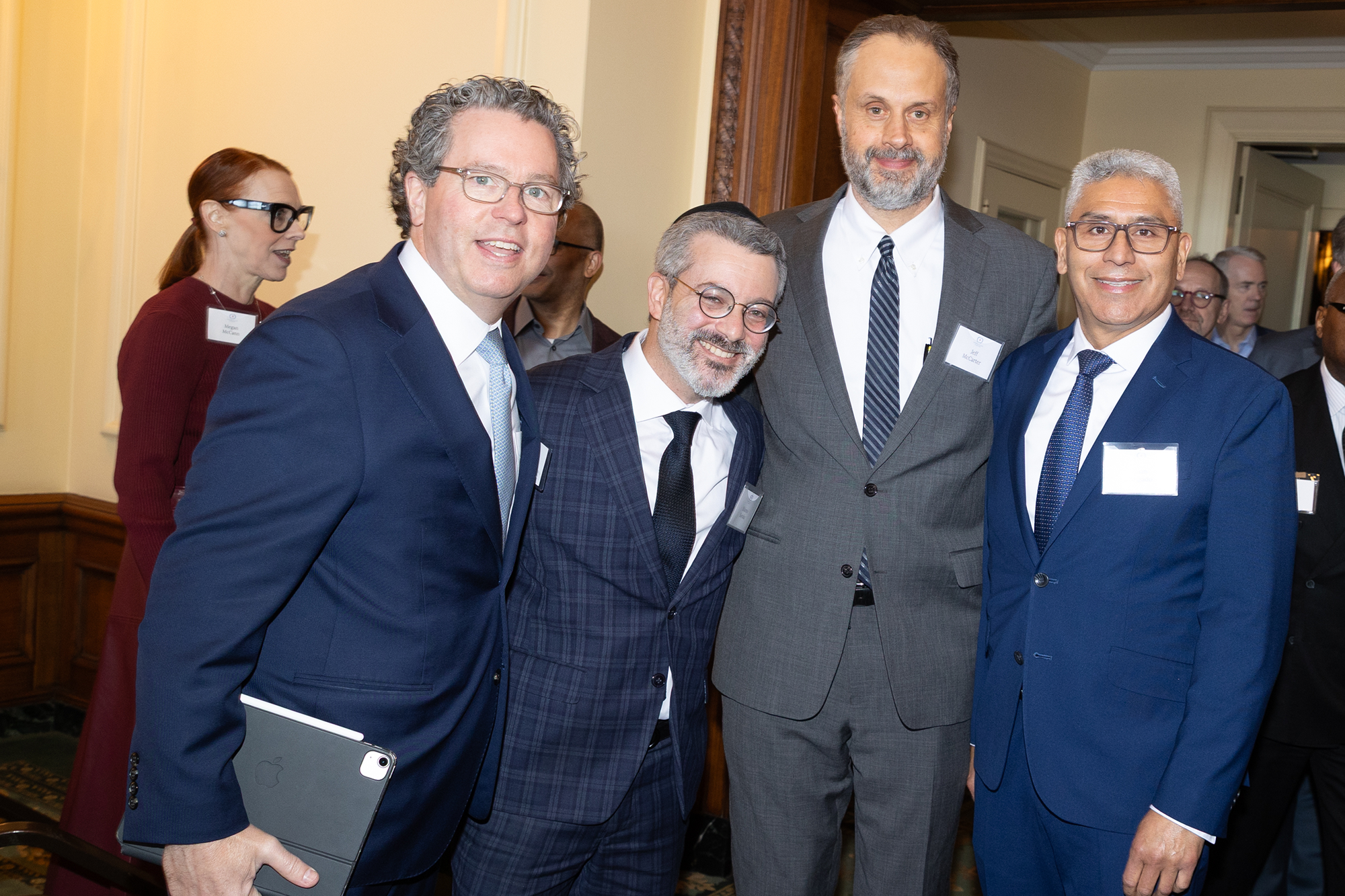 Four people stand posing together