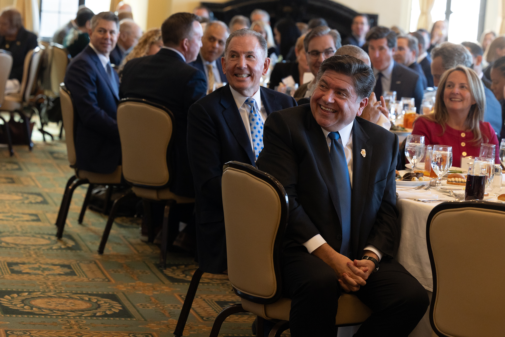 People in an audience sit at tables