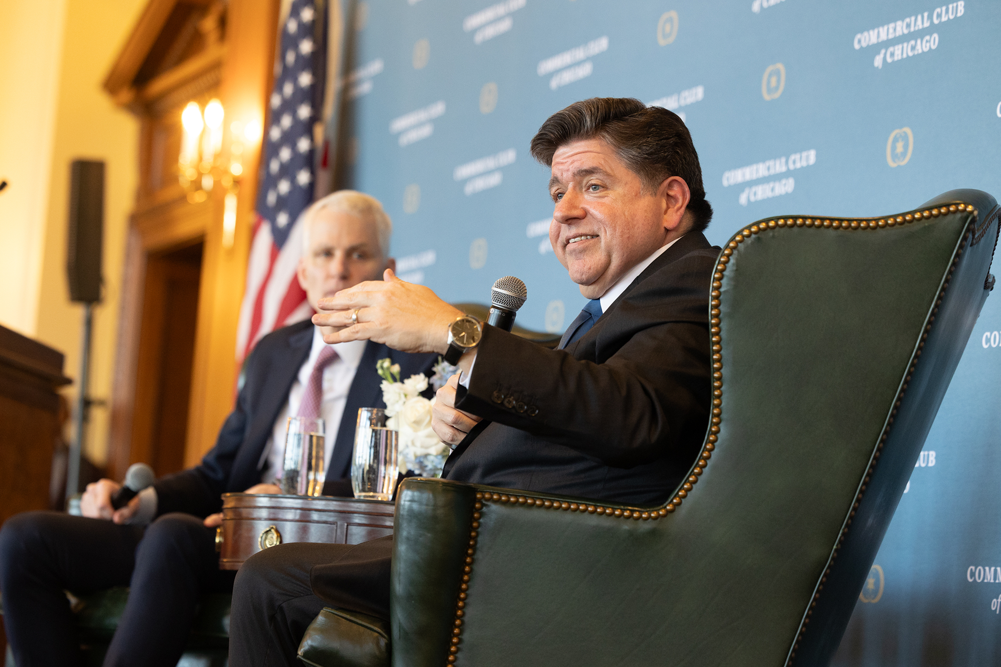 Governor Pritzker sitting in a chair on stage