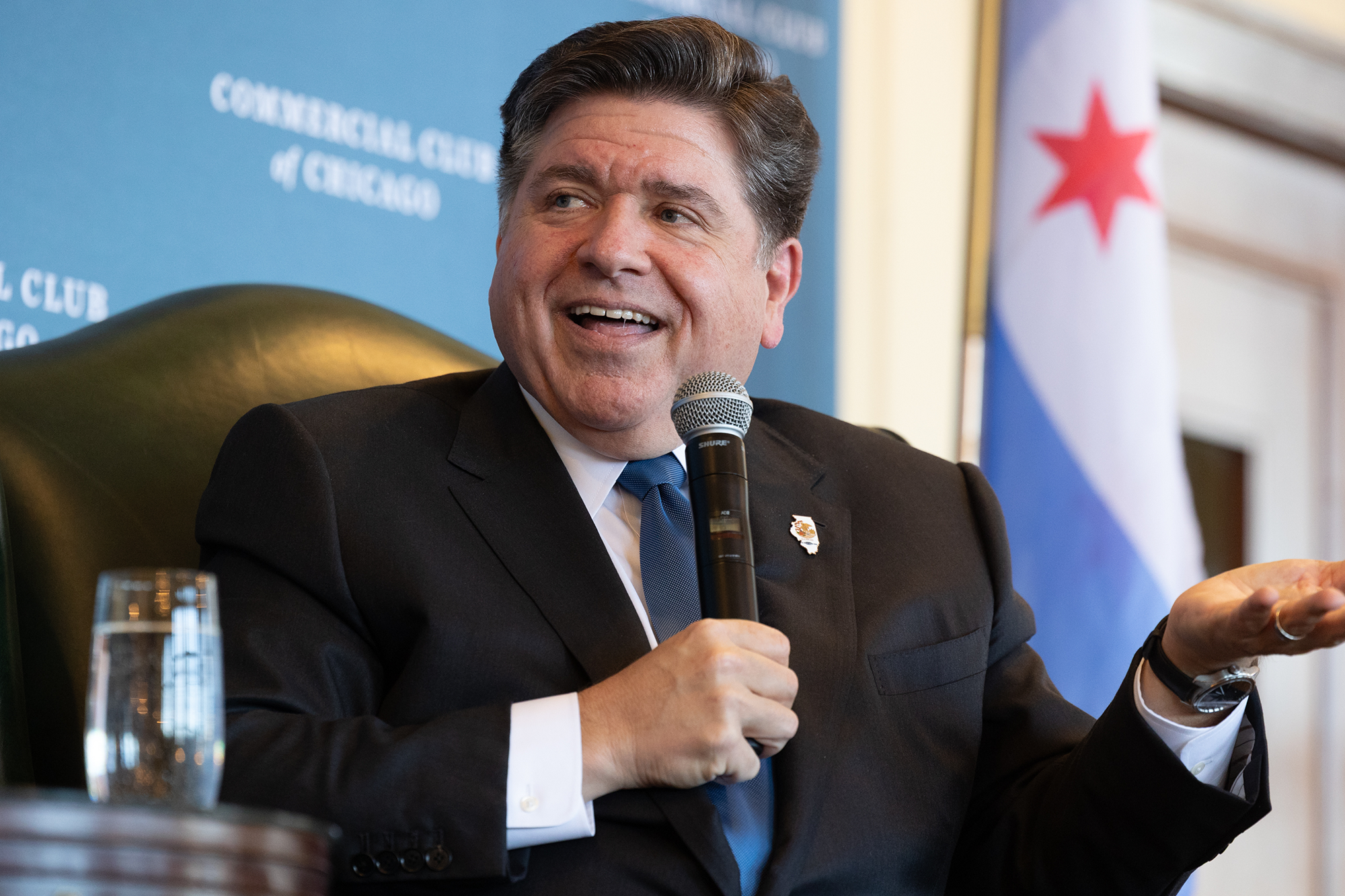 Governor JB Pritzker speaks into a microphone