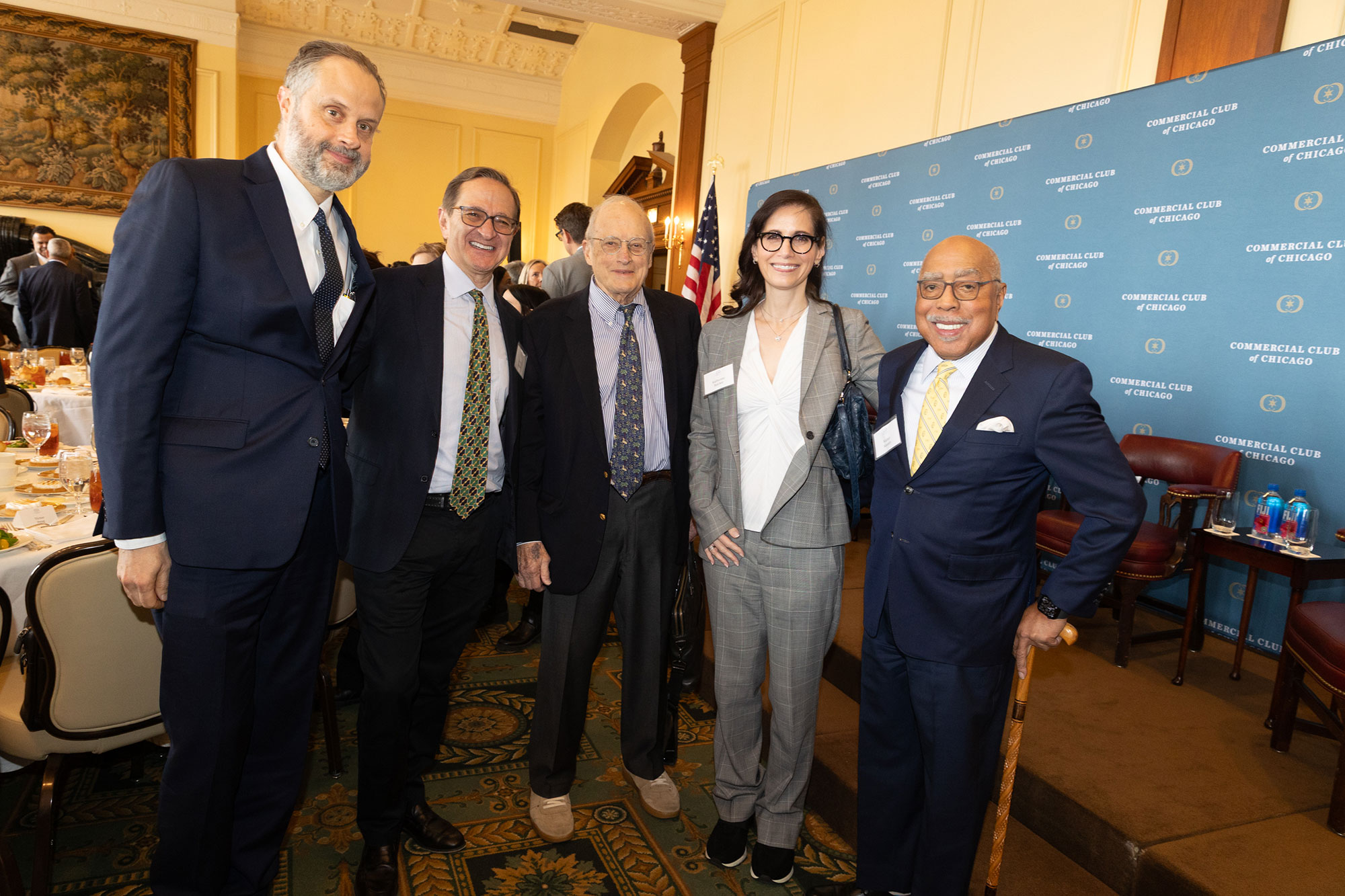 Five people stand together posing