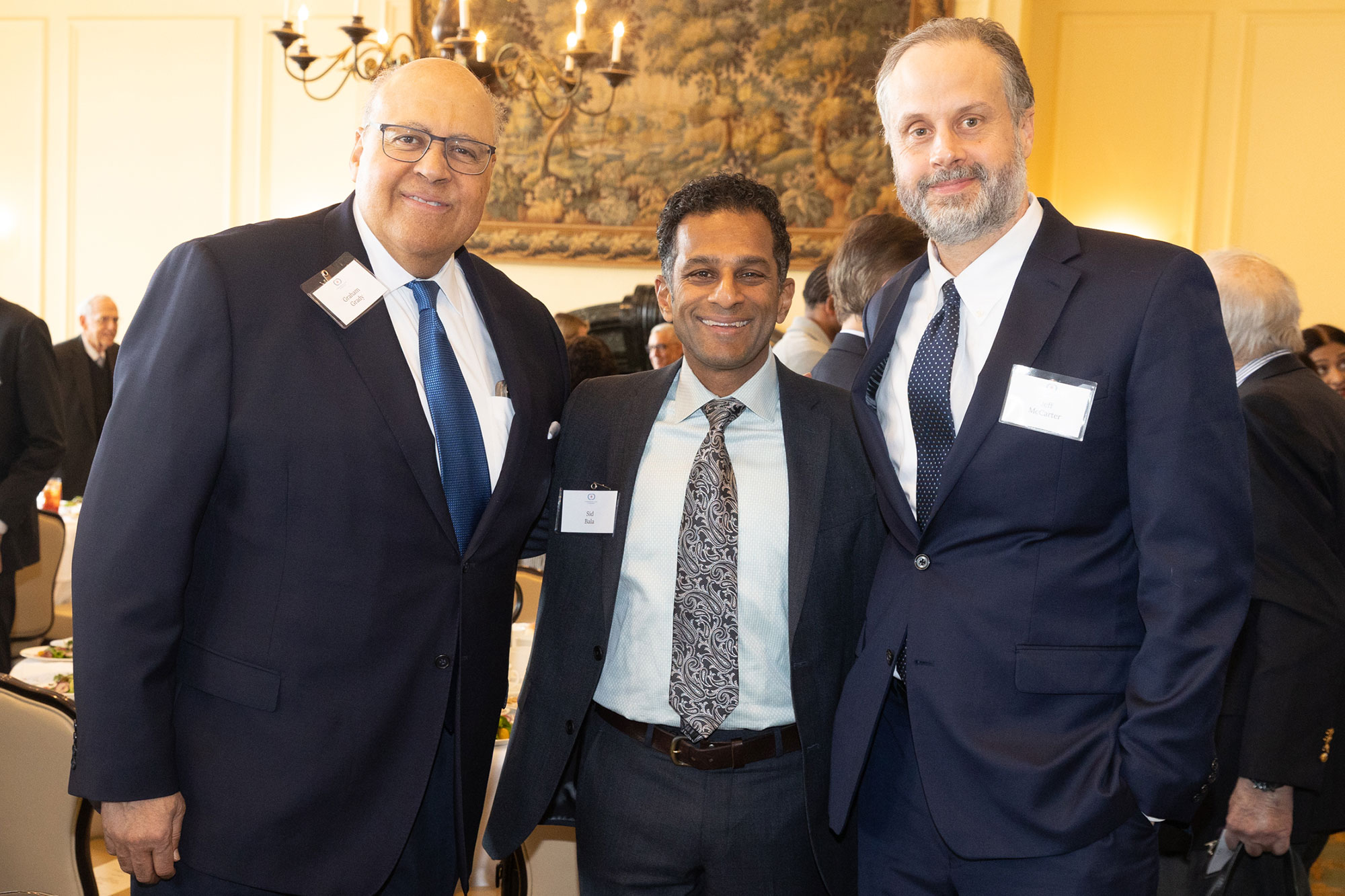Three people stand posing together