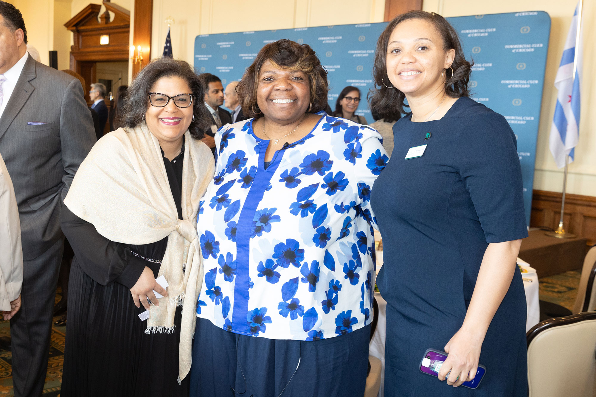 Three people stand posing together