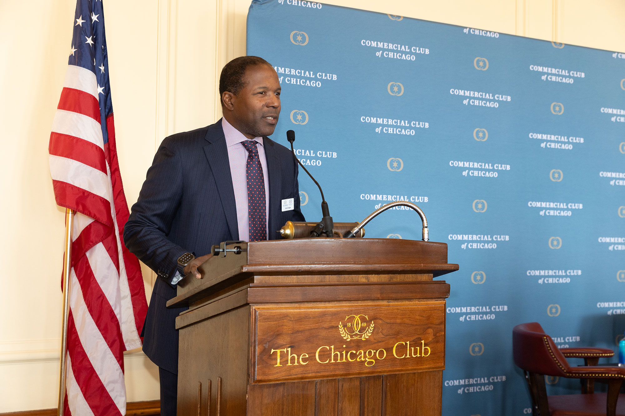 A person stands behind a podium speaking into a microphone