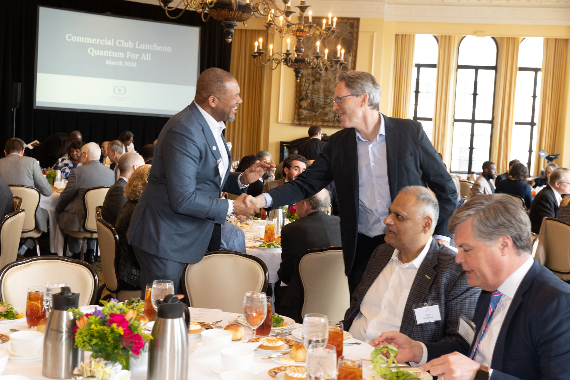 Two people stand shaking hands