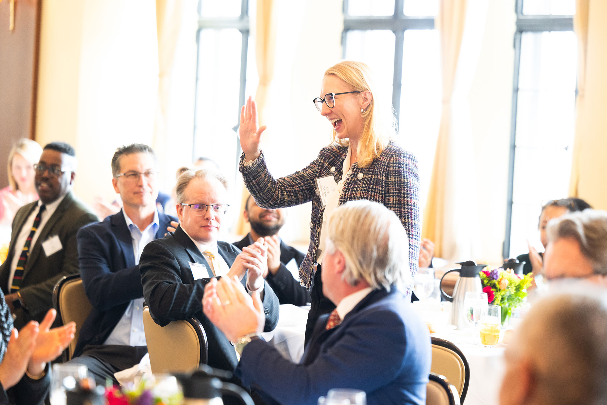 A person in the audience stands and waves