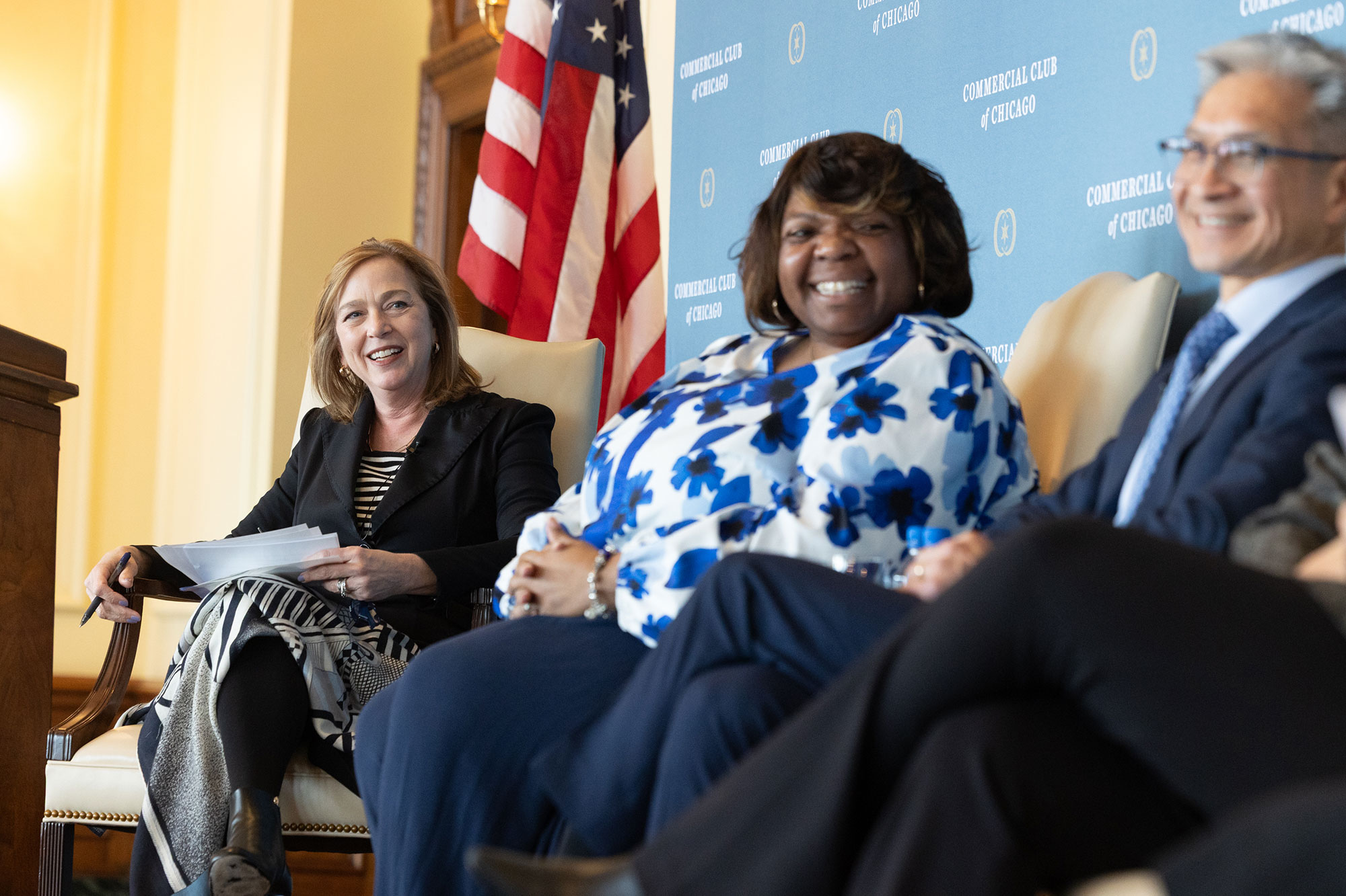 Three people sitting in chairs on stage
