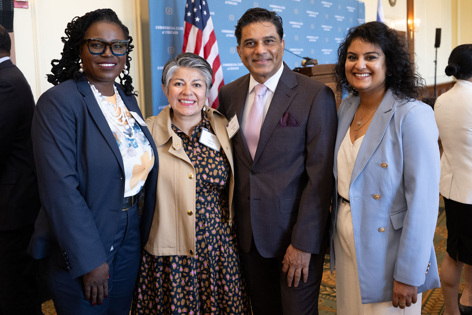 Four people stand posing together