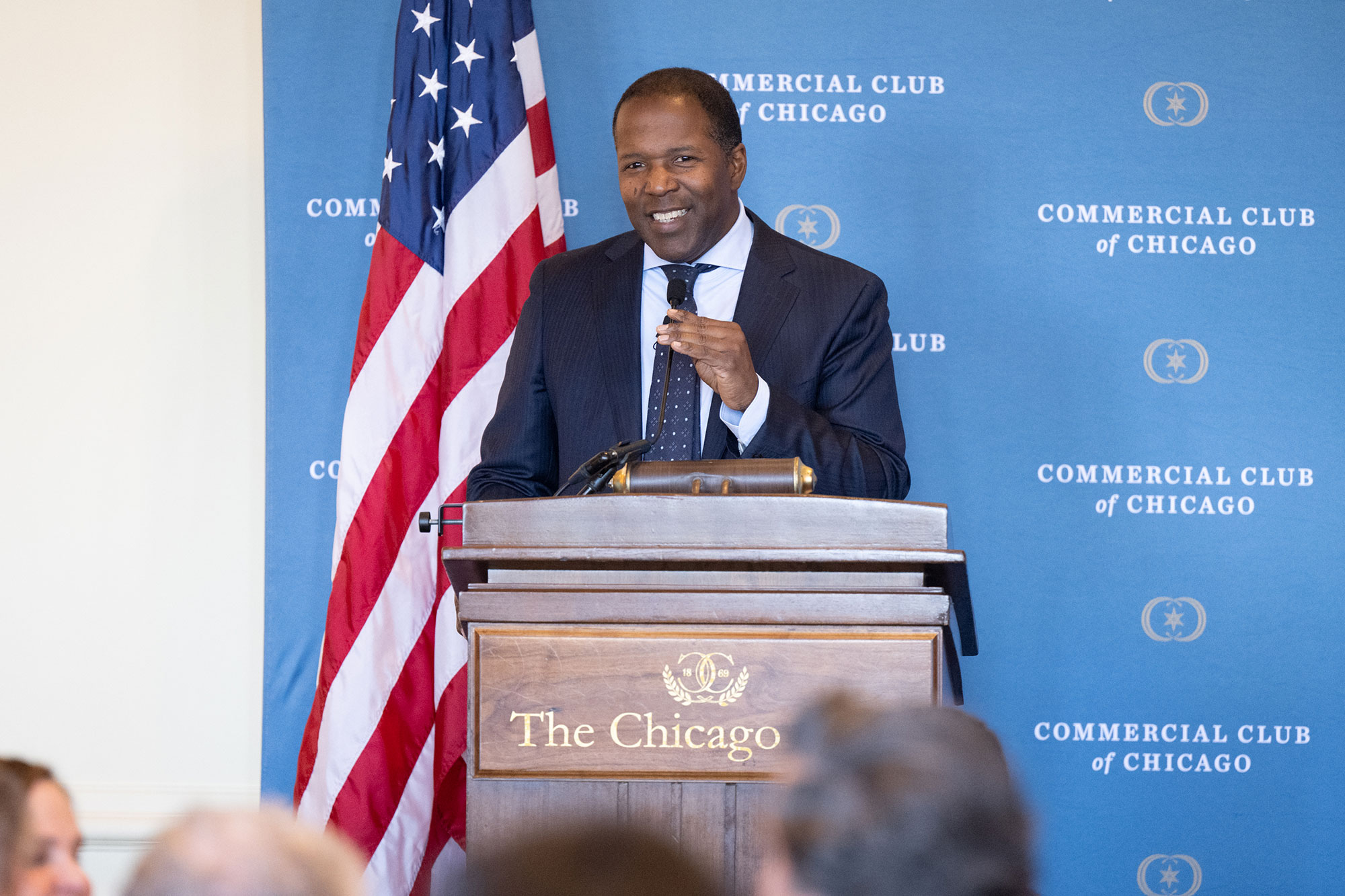 A person speaking on stage behind a podium