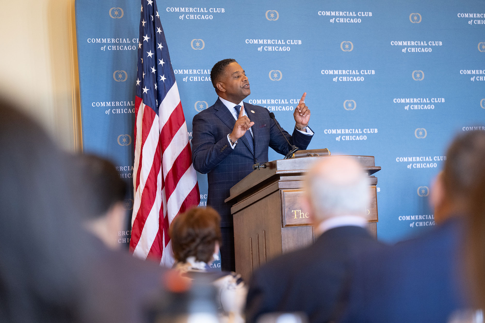 A person stands behind a podium speaking into a microphone