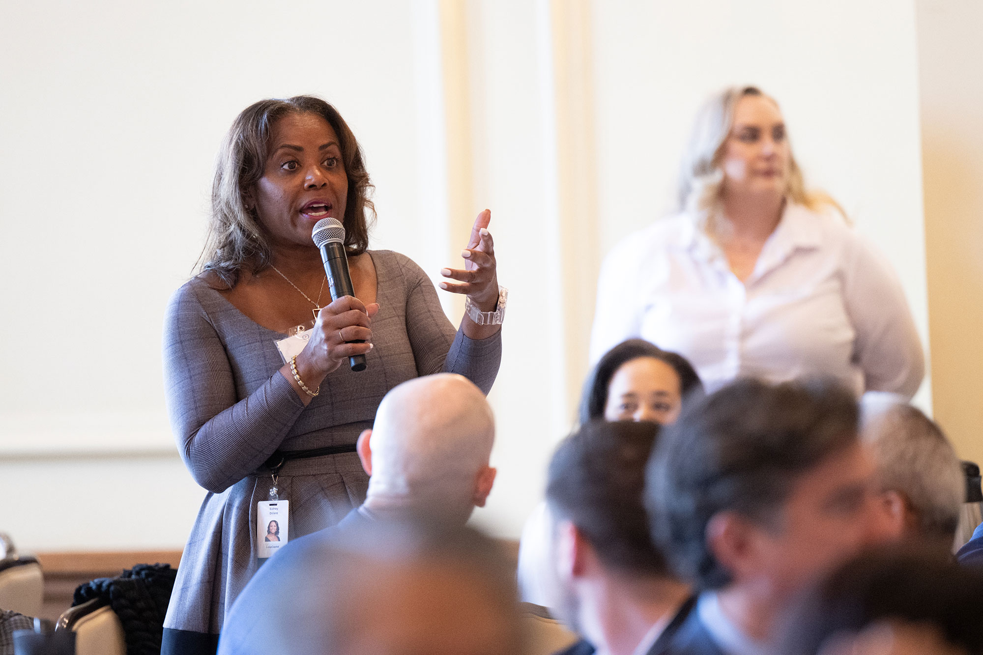 A person speaks into a microphone in the audience