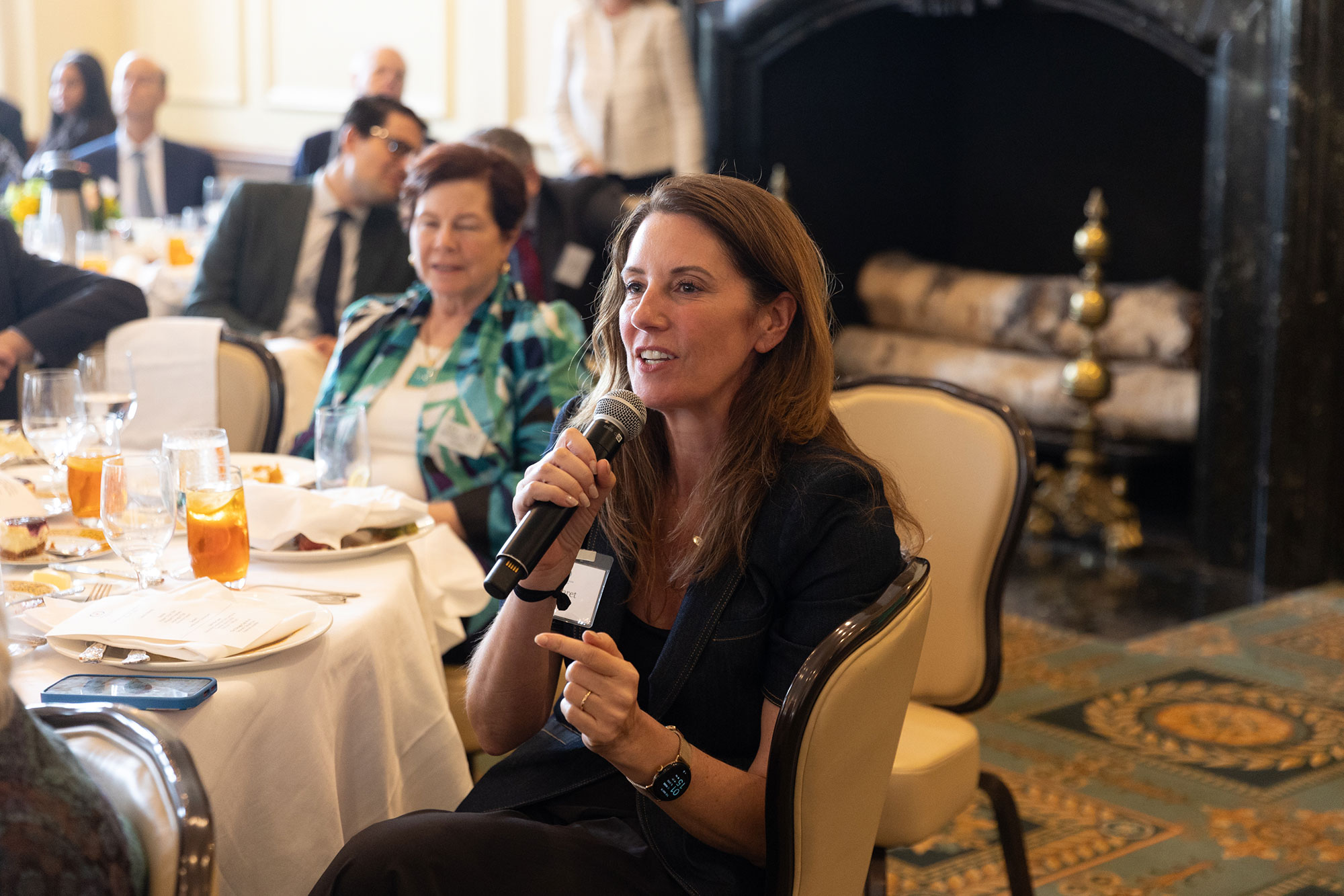A person sitting down speaks into a microphone