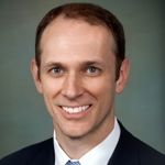 A professional headshot of a man.